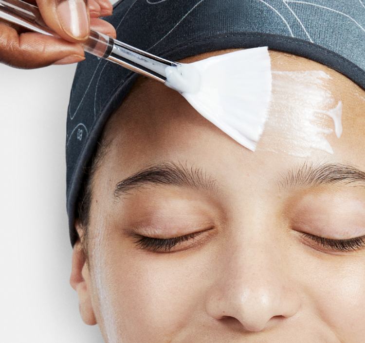 A facial mask being brushed gently onto the skin