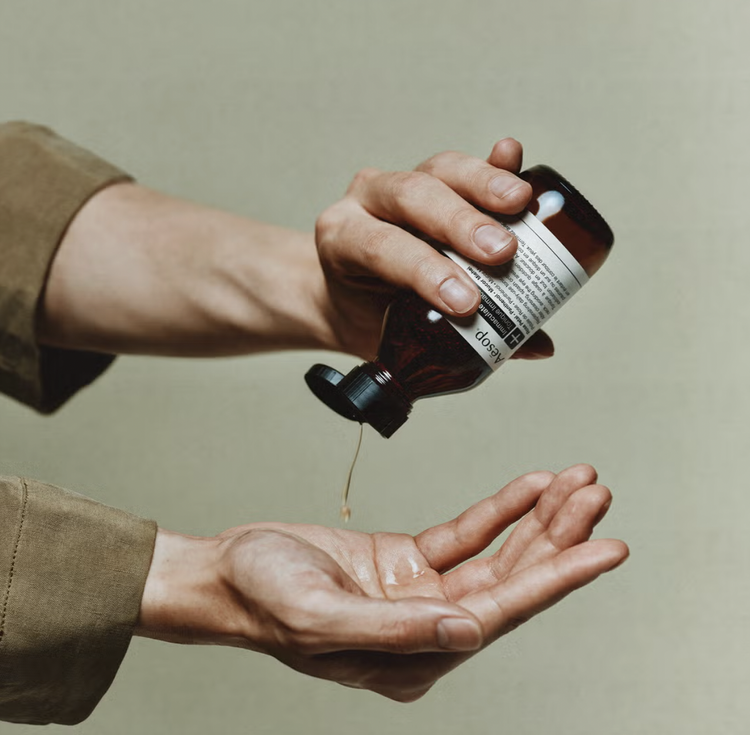 Aesop botanical product poured into a therapist’s palm