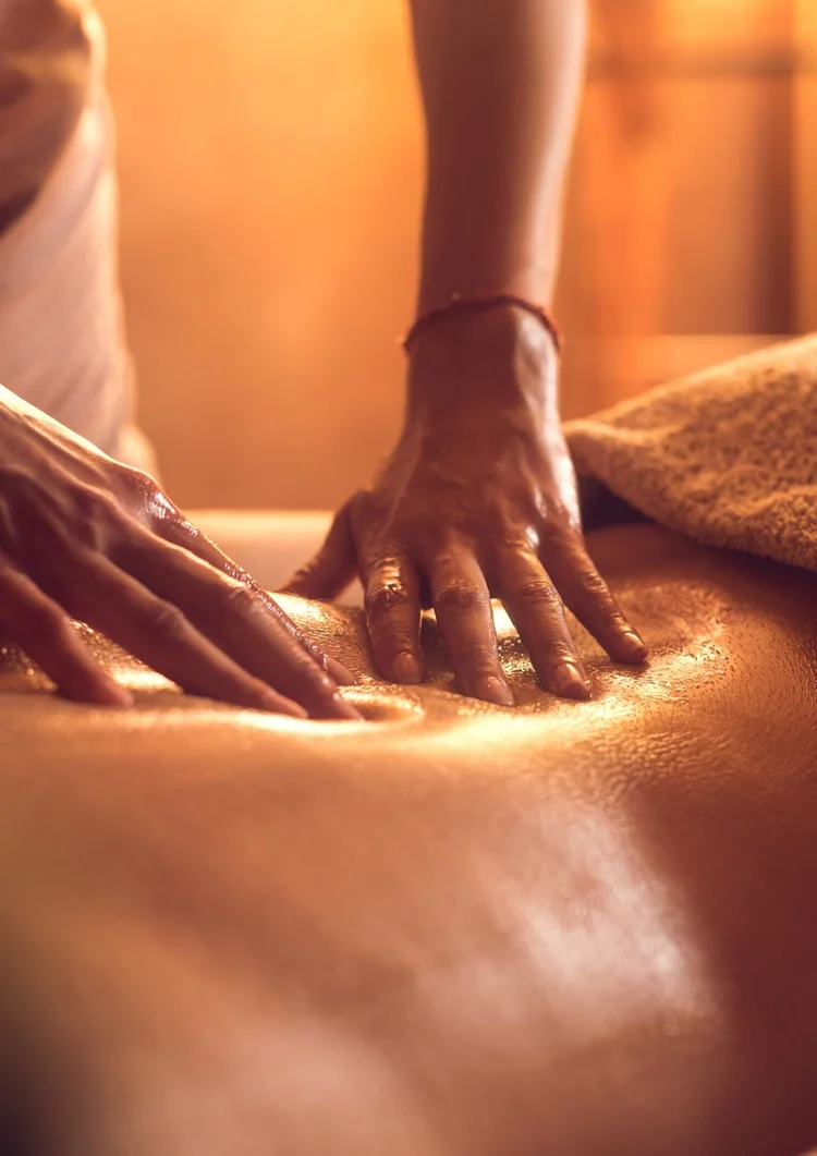 Warm massage oil glowing on a client’s back
