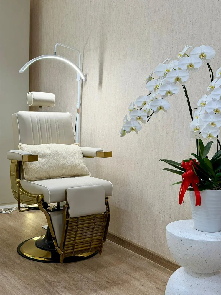 Treatment chair and white orchids at Lashes Boudoir Ploenchit, Bangkok