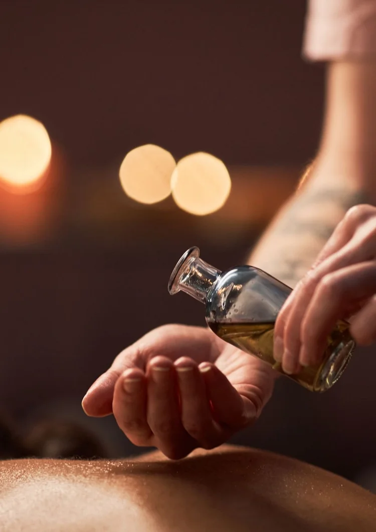 Therapist pouring warm aromatic oil into her hand