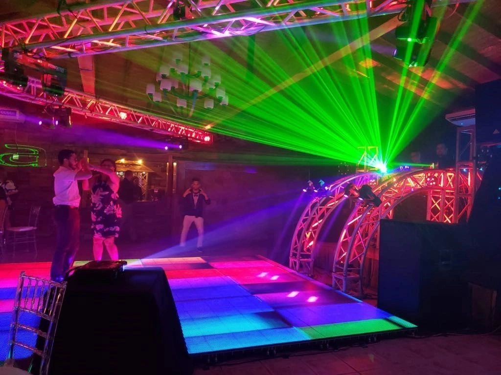 Colorful dance floor with laser lights and dancing people at an indoor party.