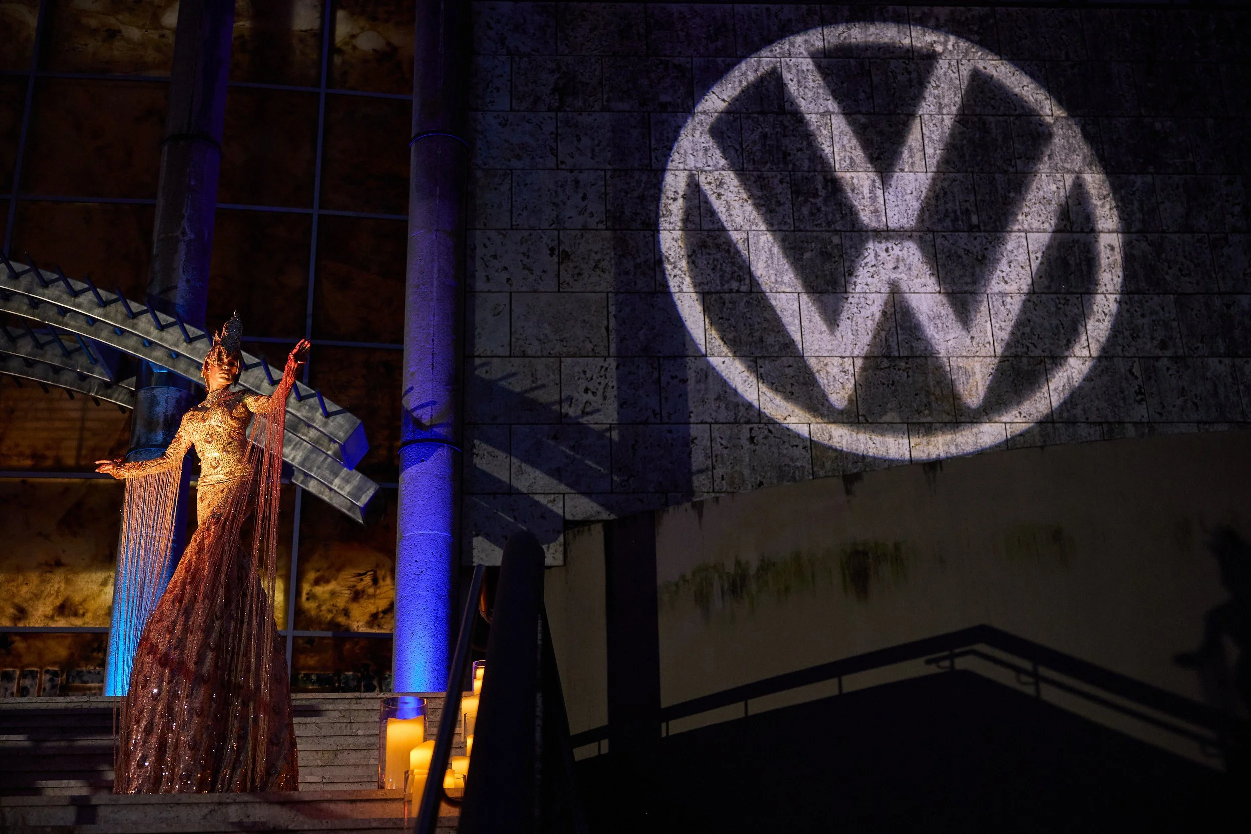 Projection on a building with the text 'I Heart PR' at night, palm tree and structure visible below.