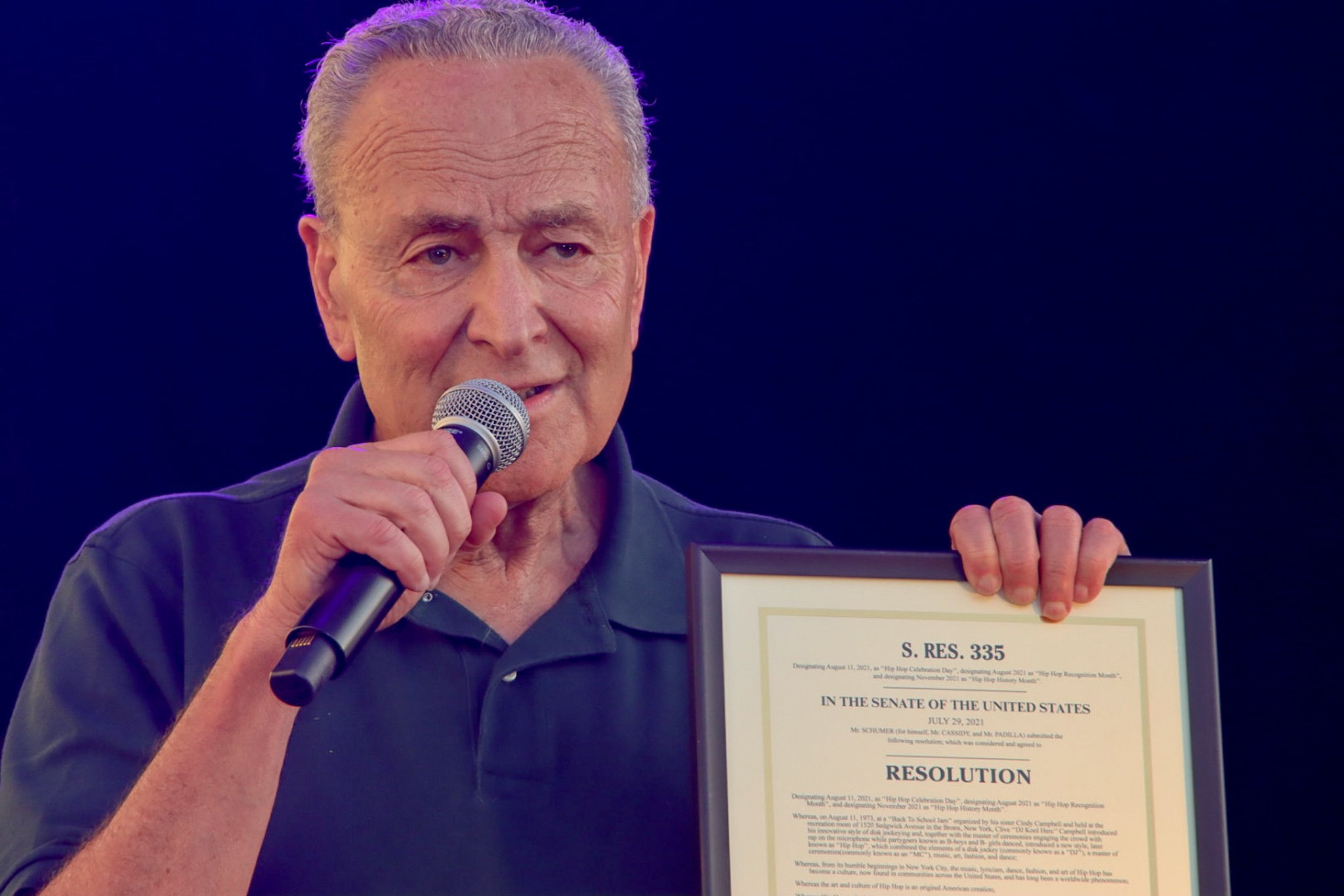 Senator Chuck Schumer holding a proclamation for the 50th anniversary of Hip Hop.