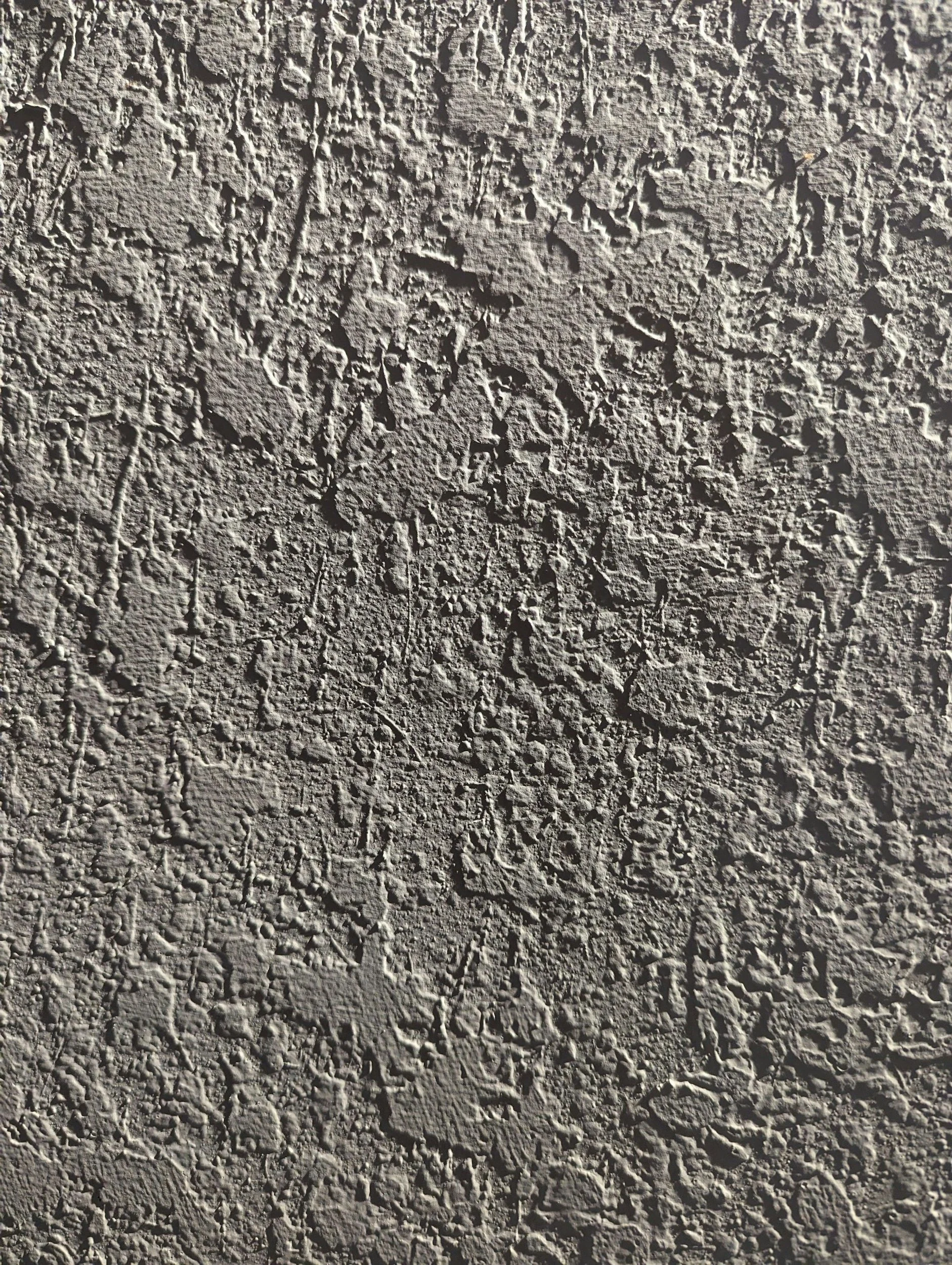 Close-up of a textured, rough concrete or stone wall surface.