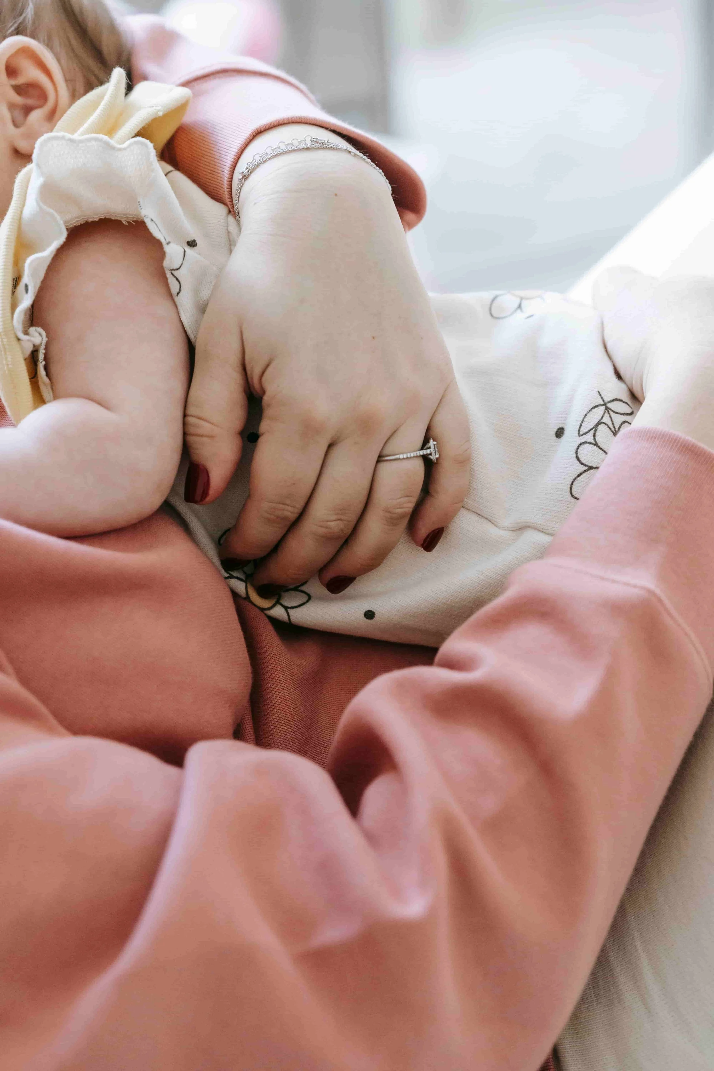 Mental Health Challenges During the Perinatal Period - Woman holding baby on her chest