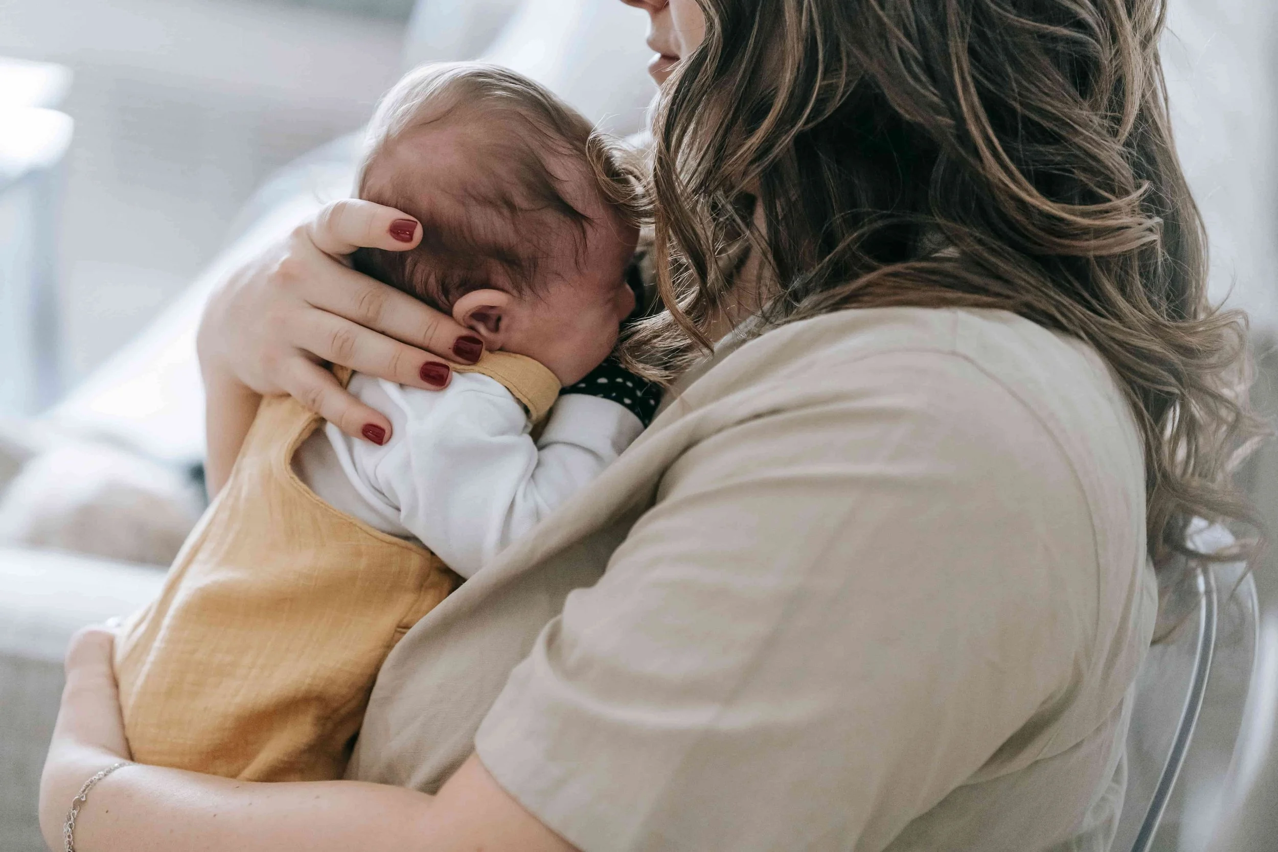 Support Options for Moms During Pregnancy & Postpartum- Postpartum mom holding a newborn baby