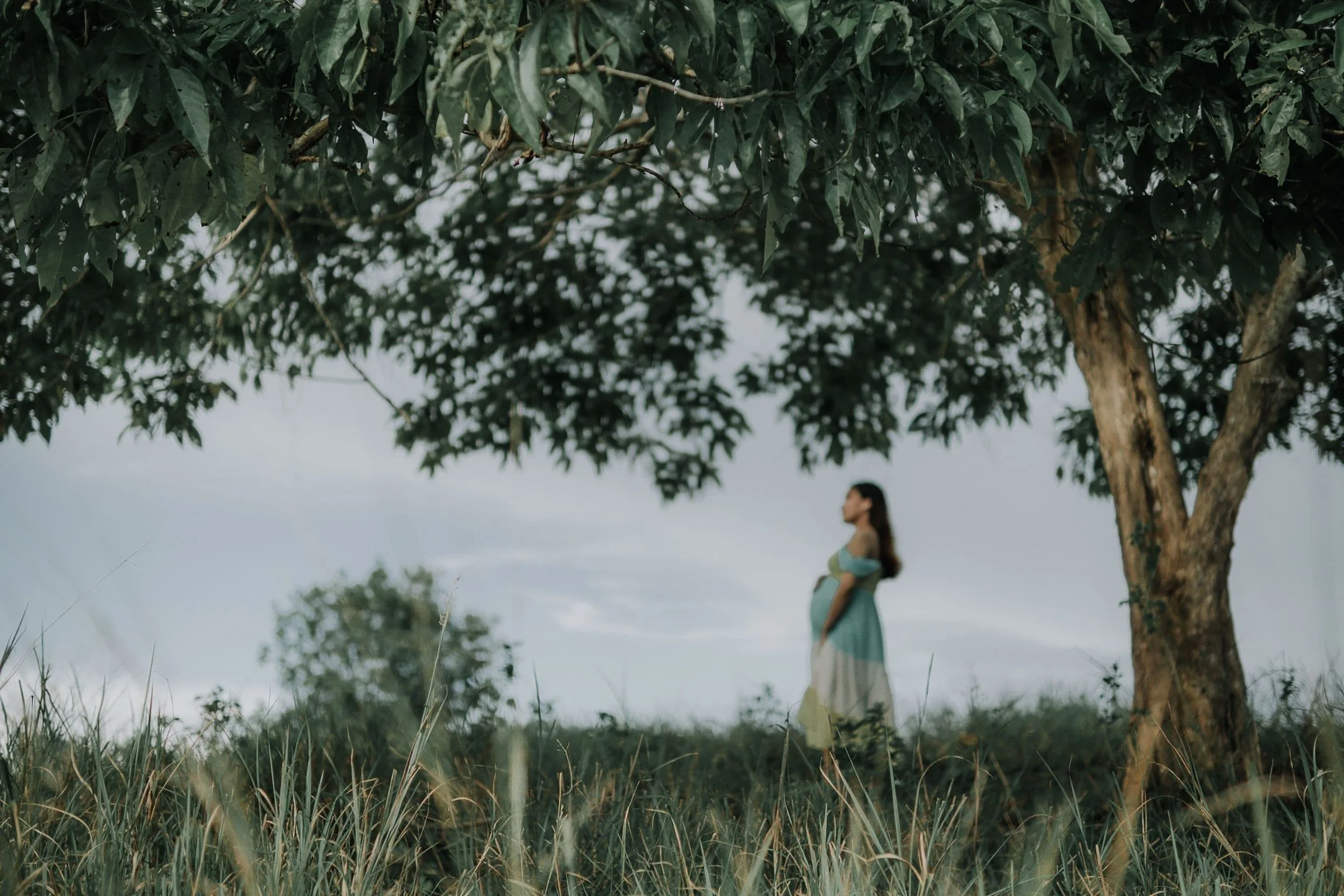 Support Options for Moms During Pregnancy & Postpartum- Pregnant woman standing in a field