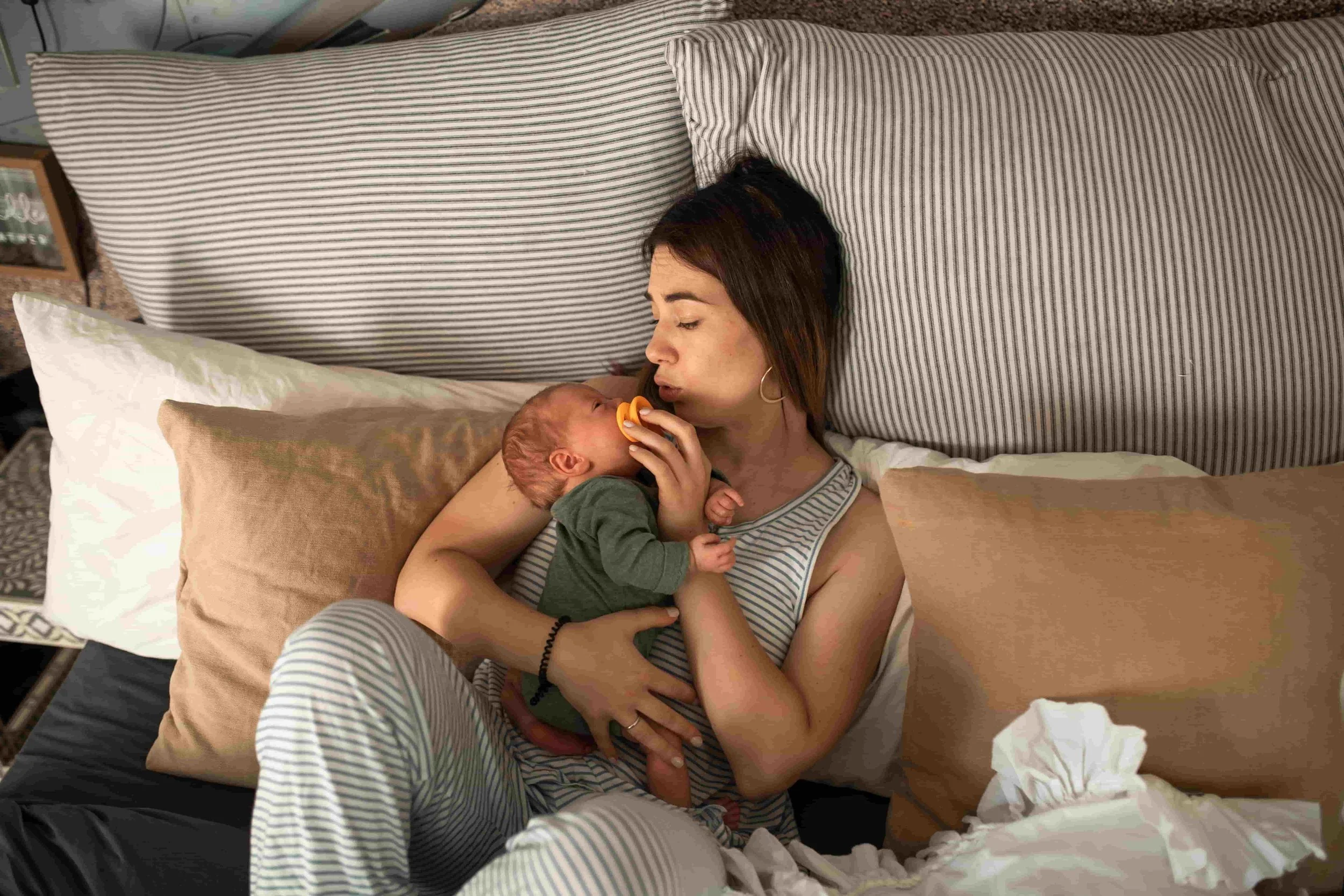 When to Seek Professional Support During Pregnancy or Early Motherhood-Mom holding a newborn baby in a bed