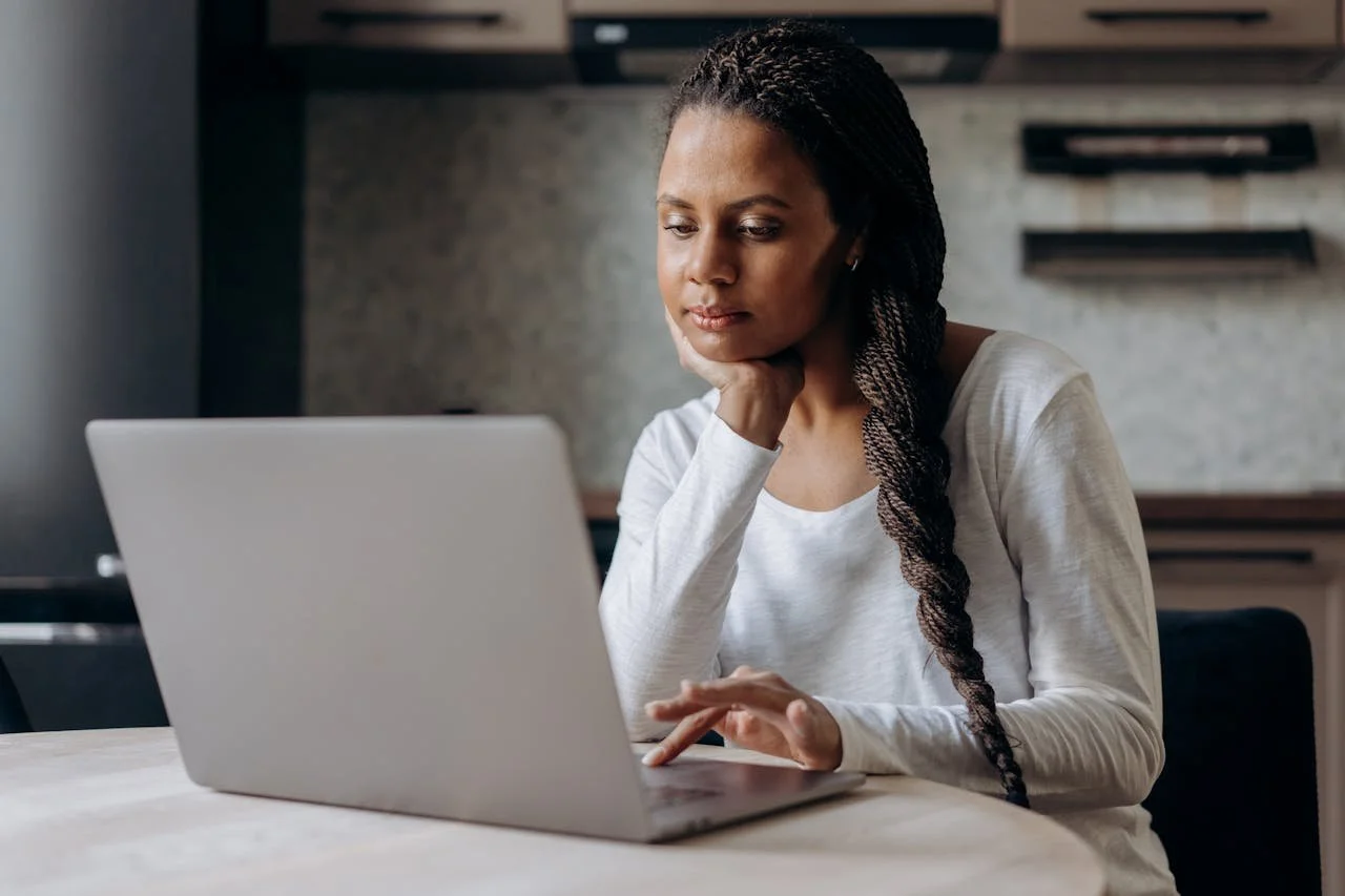 Signs Your Nervous System Is Stuck in Survival Mode- woman in front of laptop with hand on chin