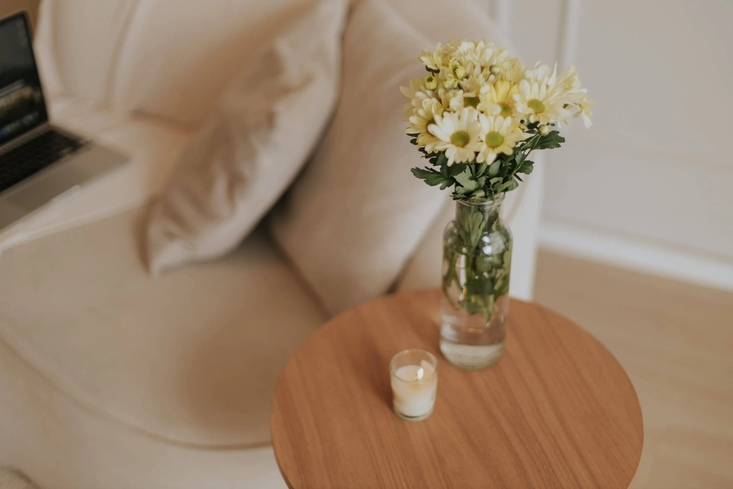 When EMDR Is Often Recommended in Trauma Treatment- Side table with yellow daisies and a small candle next to a couch