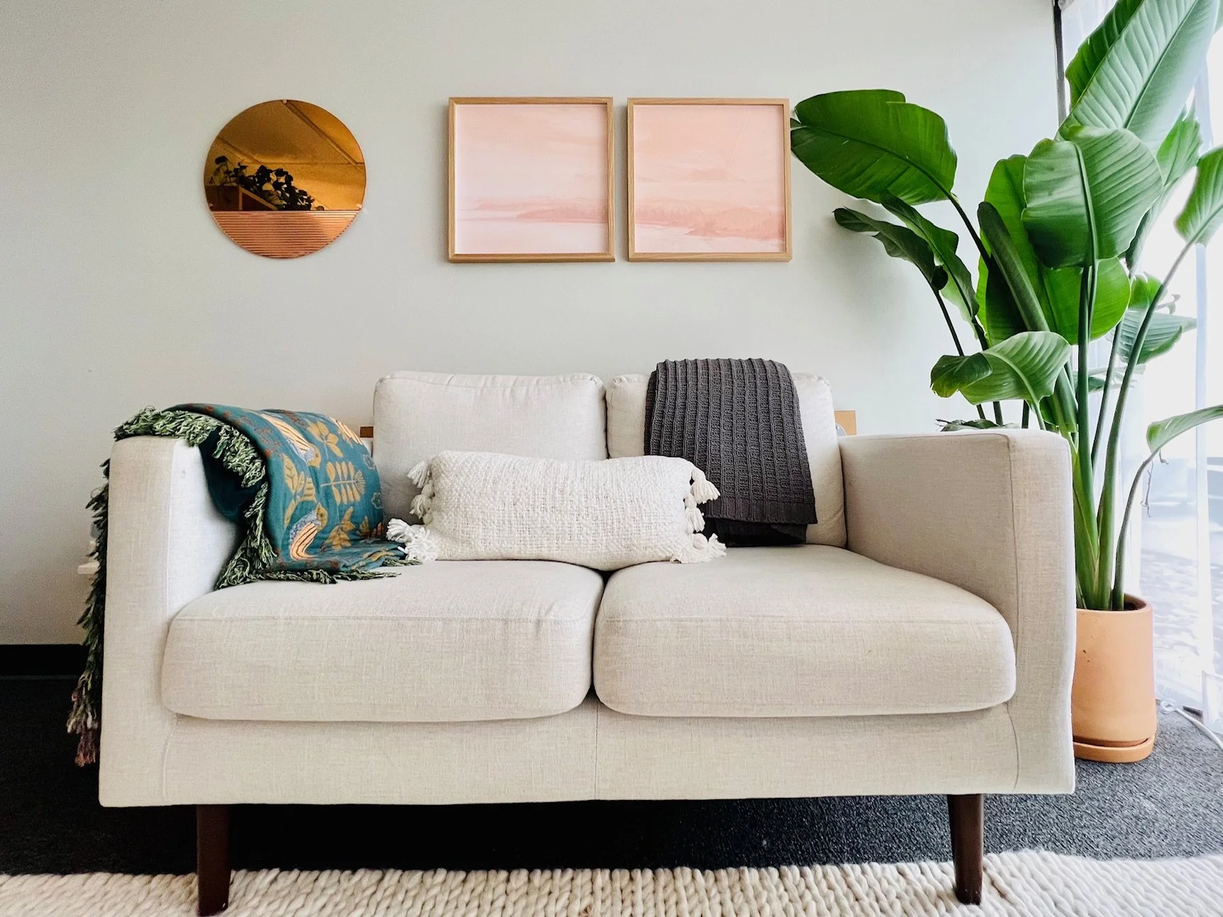 white couch with plant, mirror, and art - When Bonding With Your Baby Doesn’t Come Easily