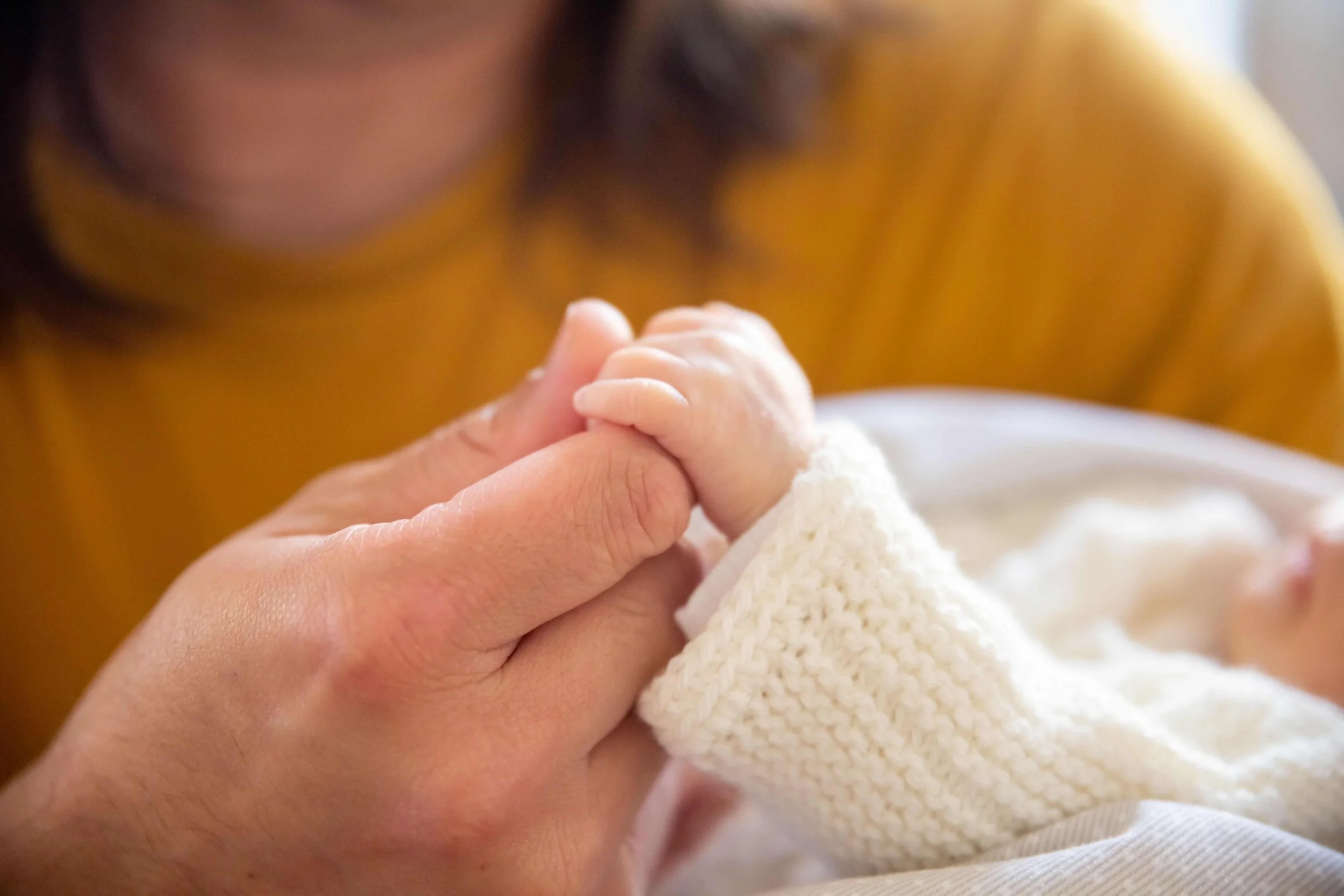 Mental Health Challenges During the Perinatal Period - woman holding baby's hand