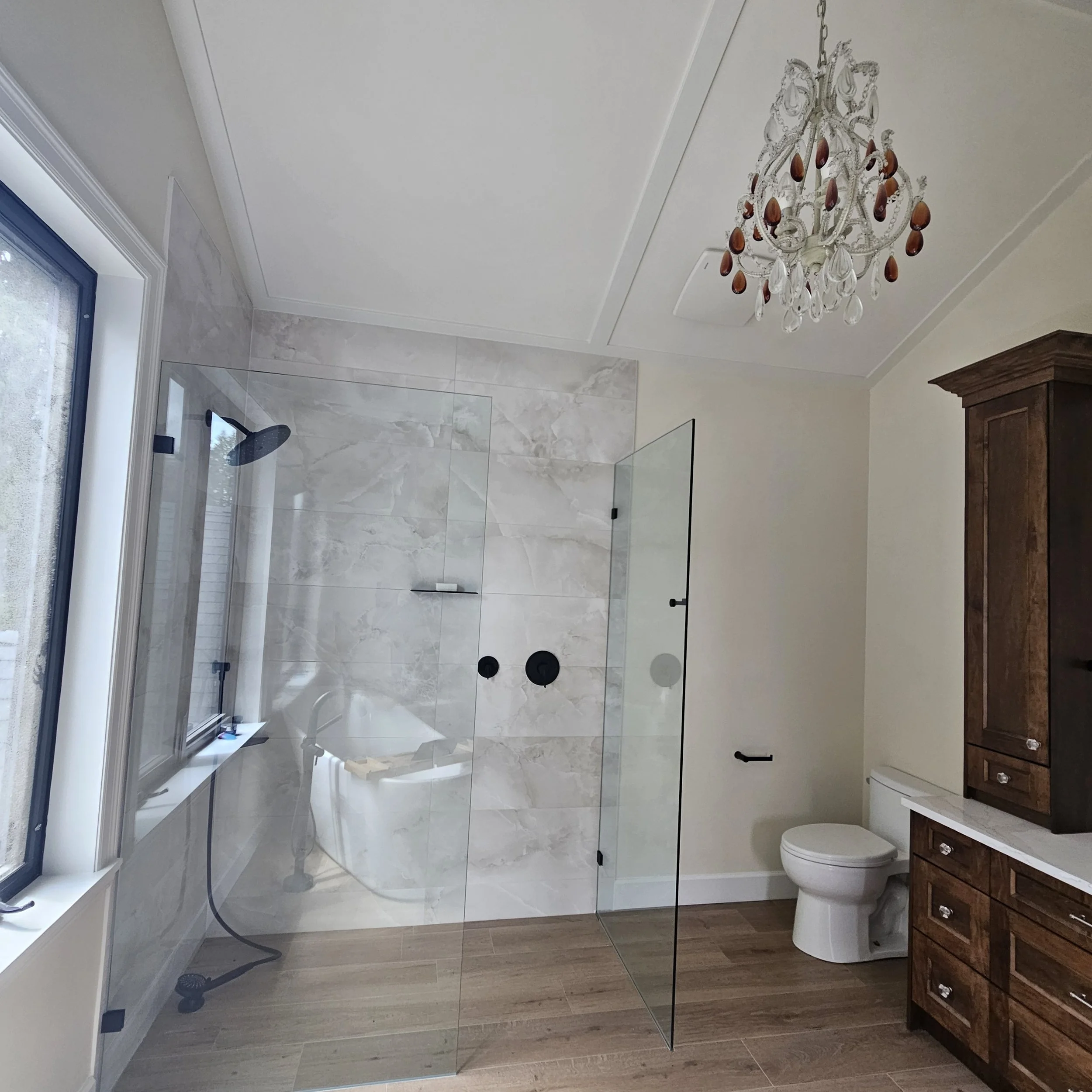A wooden exterior staircase with a railing leads to a covered deck attached to a house side.