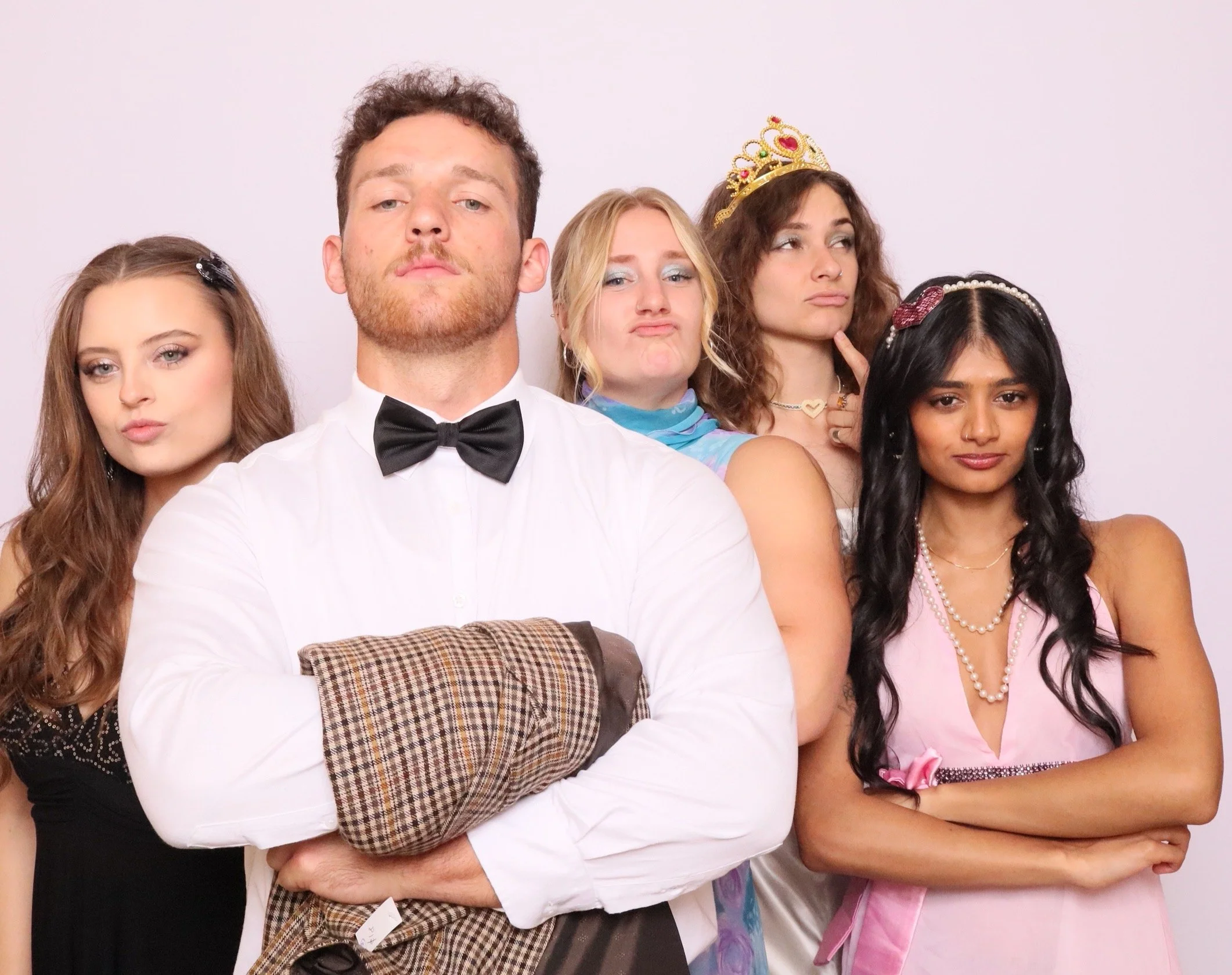 Group of five diverse young adults posing with playful facial expressions and accessories against a plain light background. This is taken on a professional photobooth by Royale Booths Photobooth Hire.