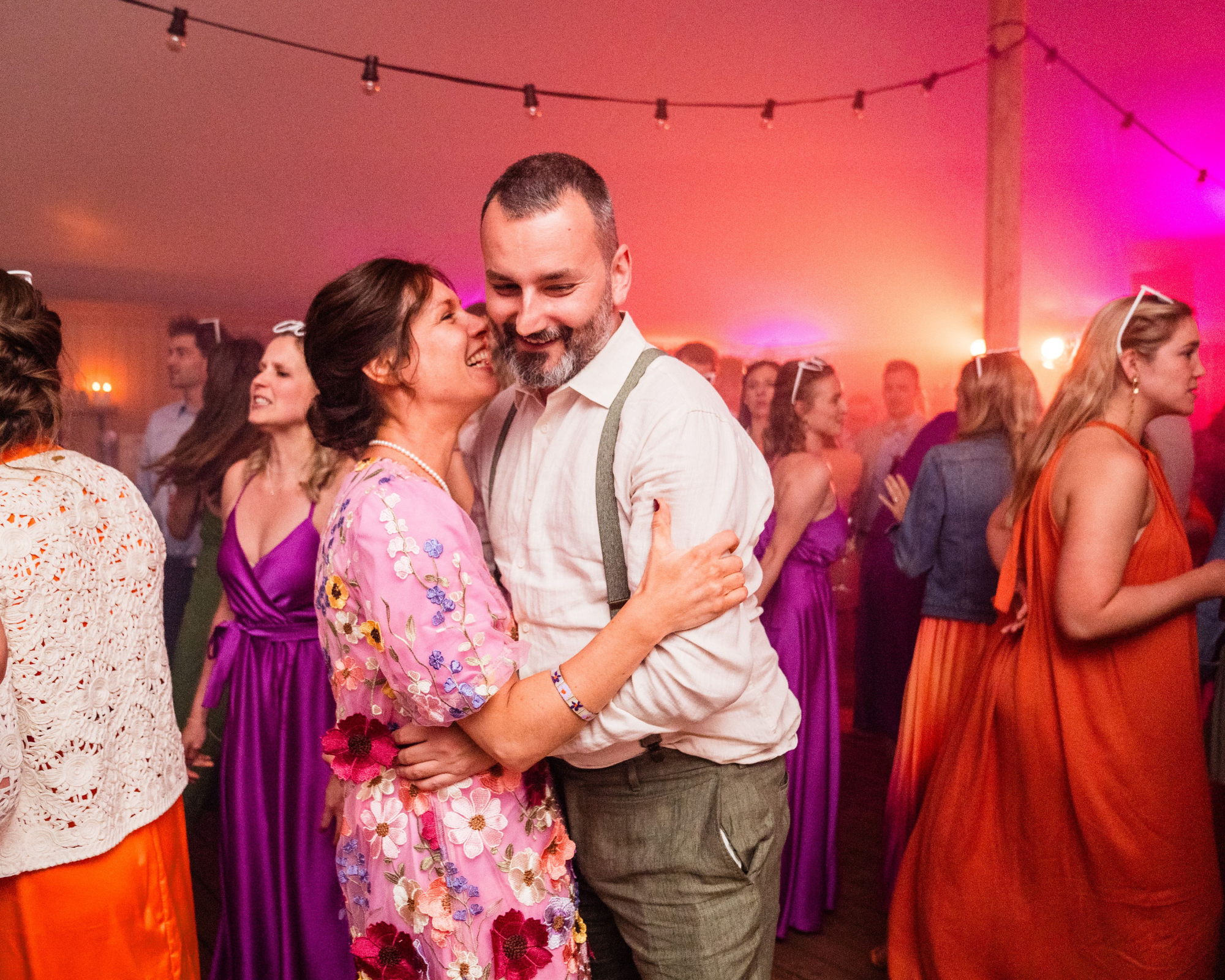 Mannen en vrouwen dansen en praten met elkaar op een feest in een tent met kleurrijk interieur. Dansfeest.