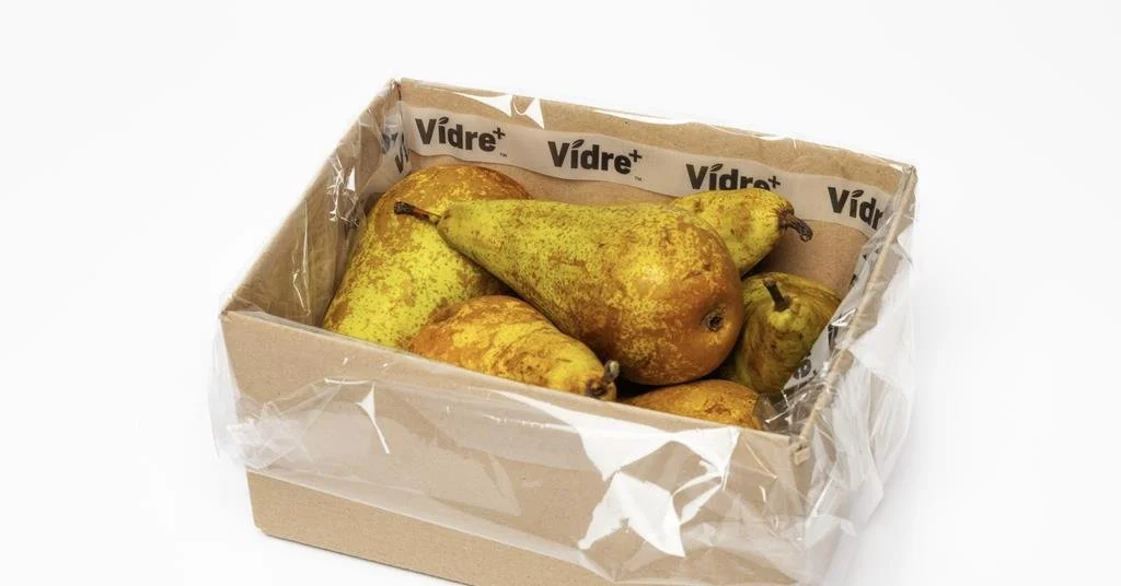 Une boîte en carton contenant des poires mûres recouvertes d'une fine couche de saleté.