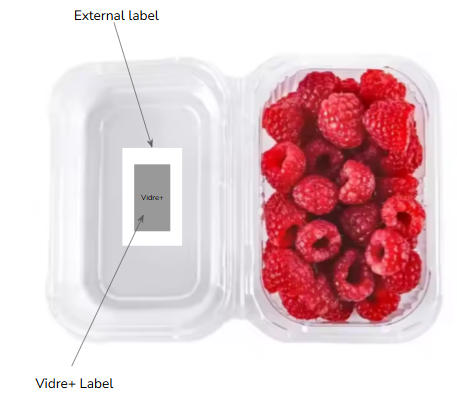 Barquettes de framboises dans un contenant en plastique avec un autocollant externe et un autocollant intérieur marqué "Vidre+".