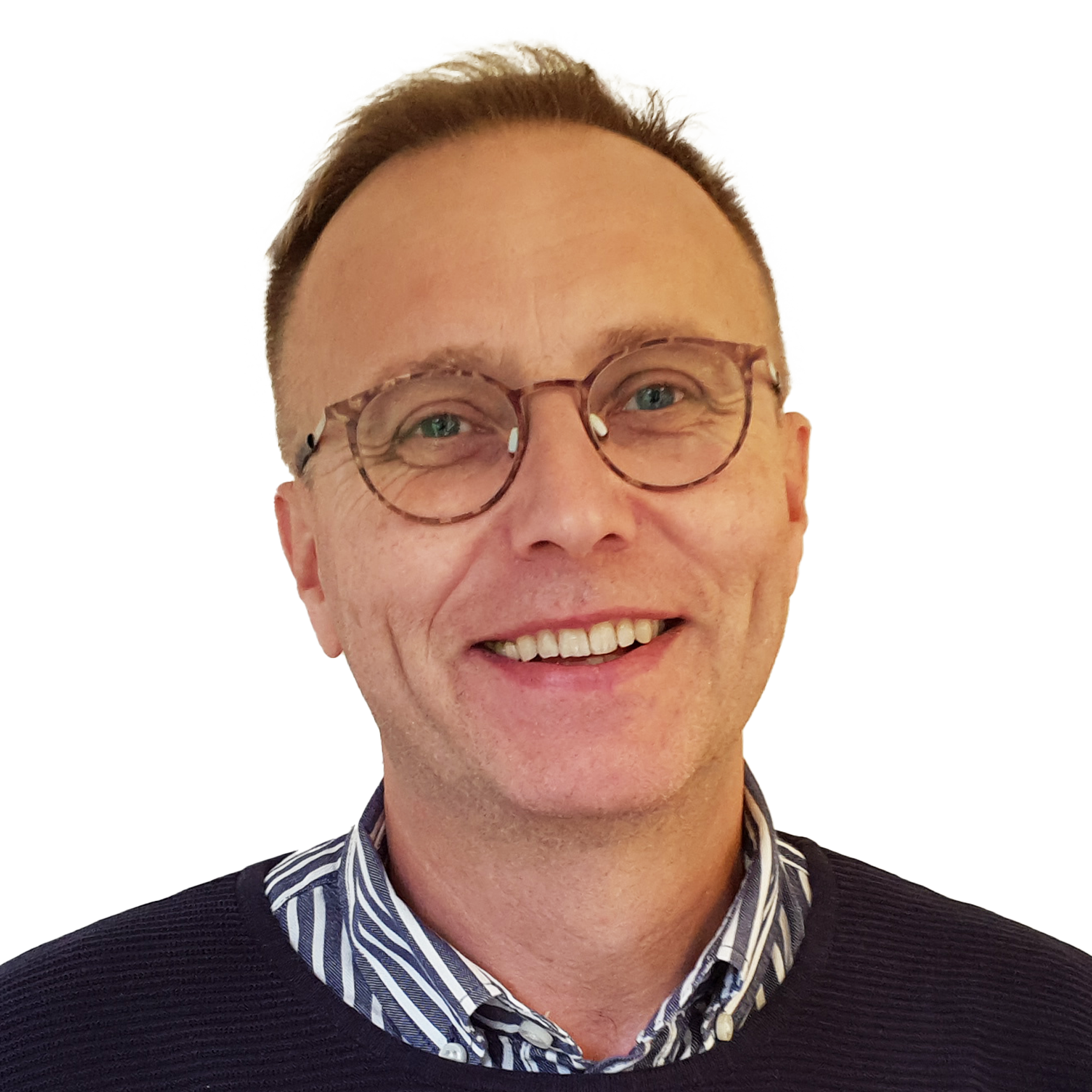 En man med glasögon, ljus hud och högt hår, ler mot kameran.