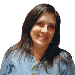 Porträtt av en kvinna med mörkt hår, ljus hud, leende, bärrad blå tröja, mot en transparent bakgrund.