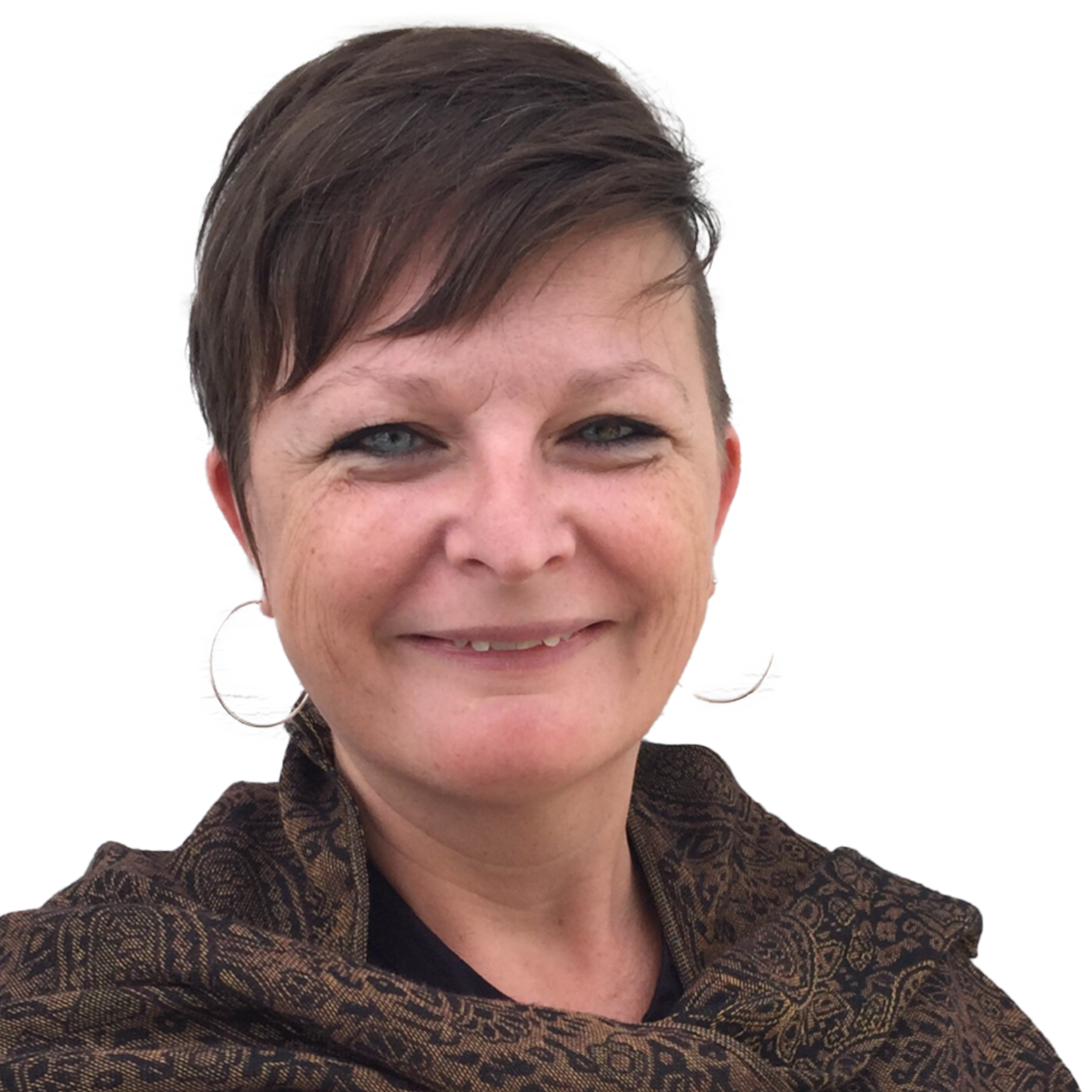 En leende kvinna med kort brunt hår, stora hoops och mönstrad sjal, utomhus.