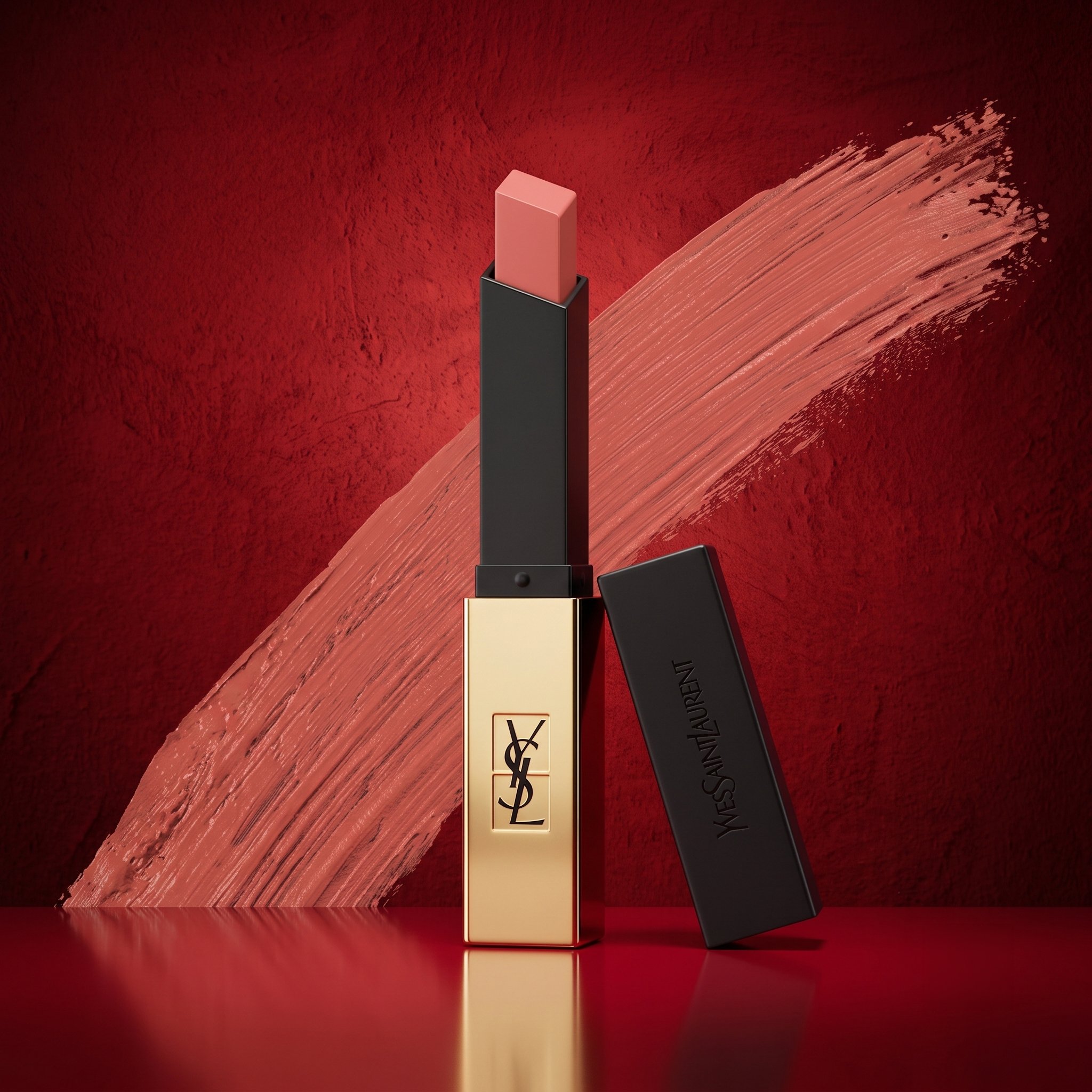 Close-up of various lipstick tubes arranged against a red textured background, with a smear of lipstick paint near the top right.