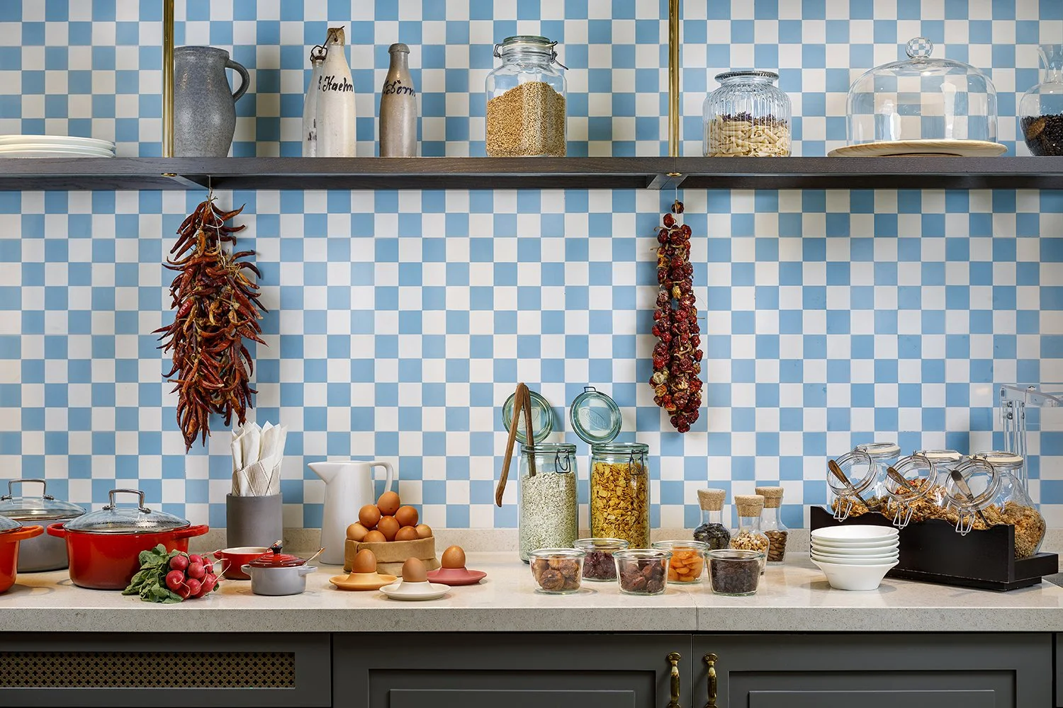 Breakfast room in front of a wall with blue 
and white chequered tiles, with various 
ingredients on it