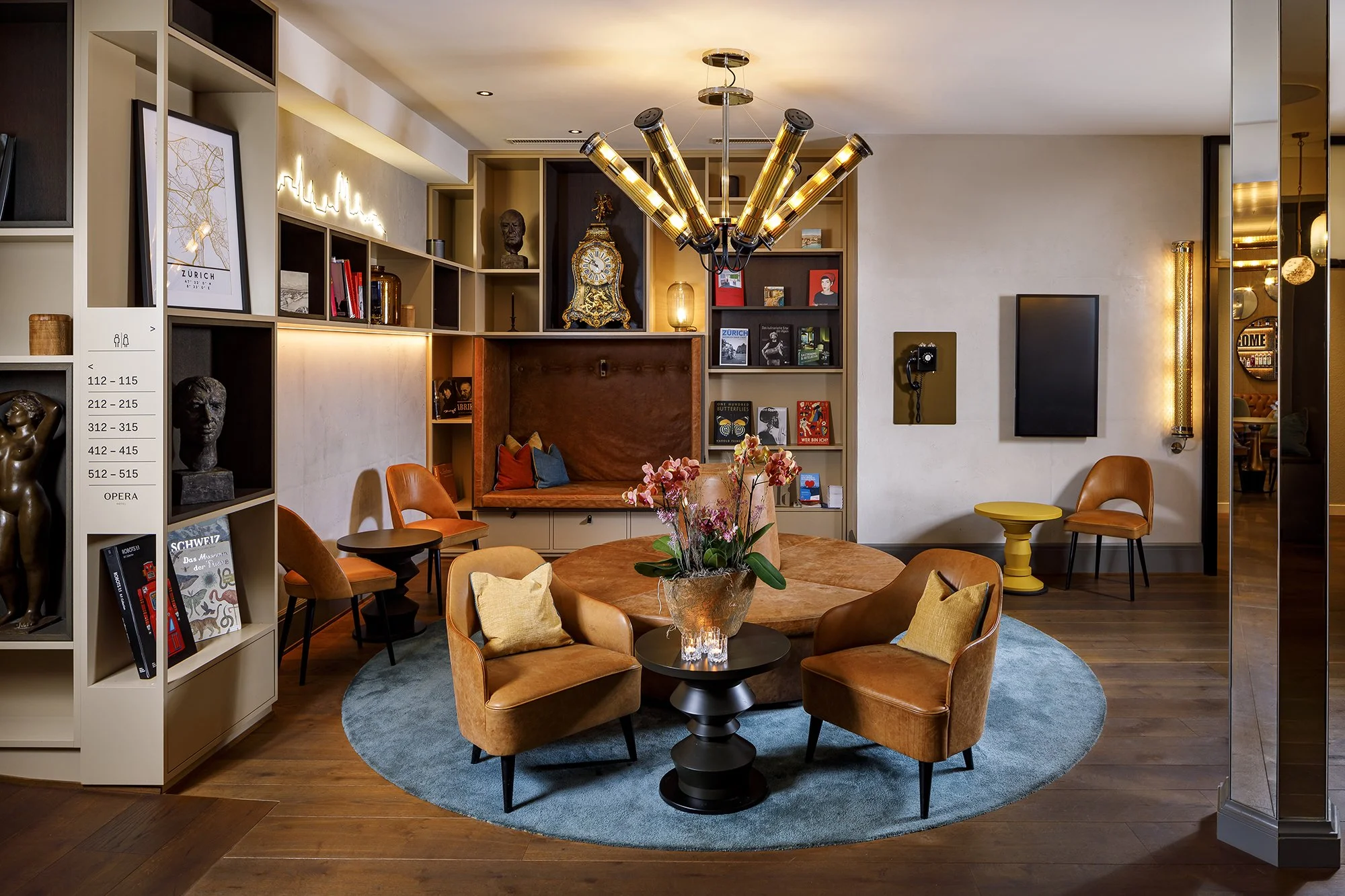 Cosy and stylishly furnished hotel lobby with 
leather furniture and a large wall shelf