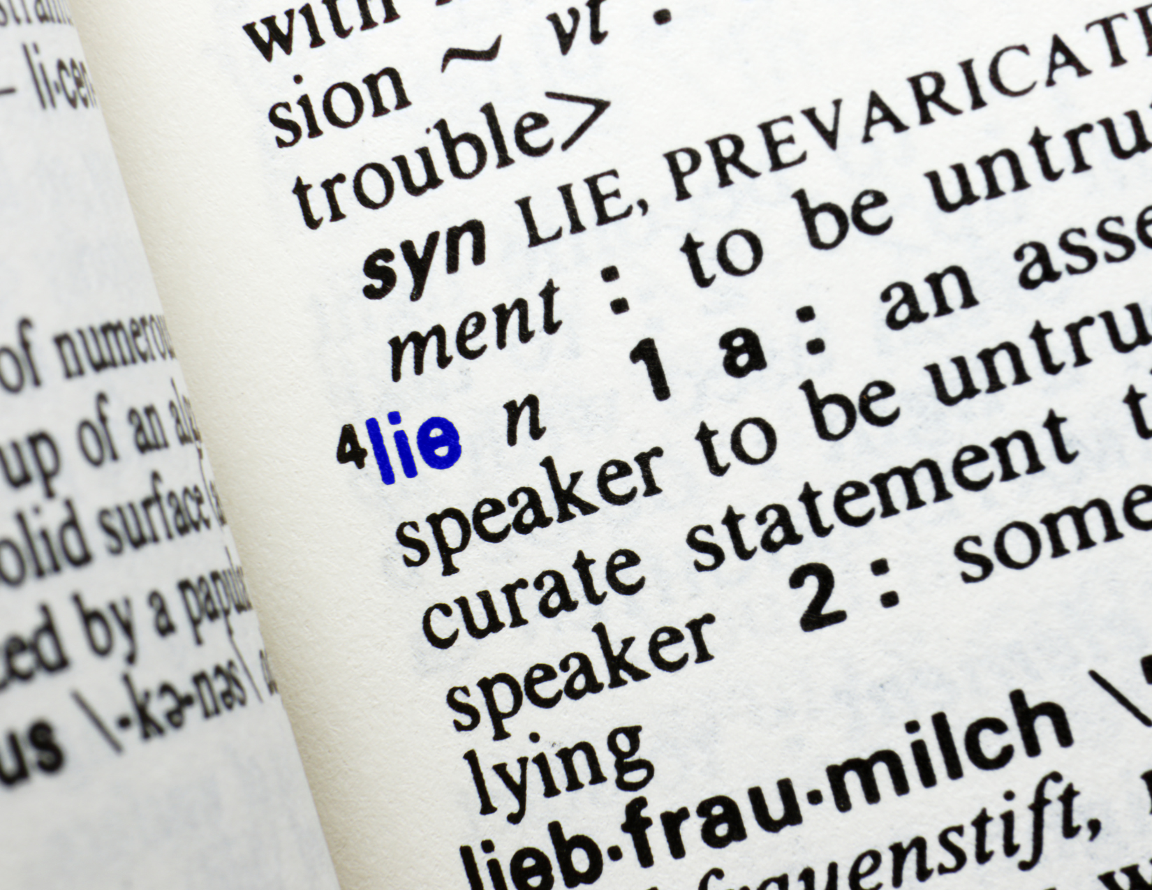Close-up of a dictionary page showing the word 'lie' with the phonetic pronunciation in blue, and the start of its definitions.