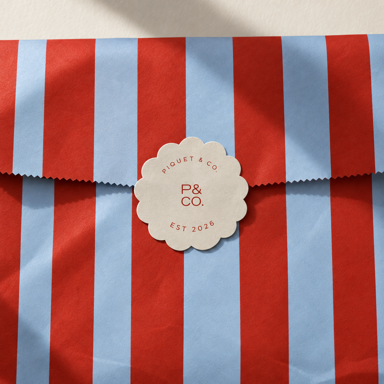Piquet & Co. red and powder blue striped packaging with scalloped brand seal