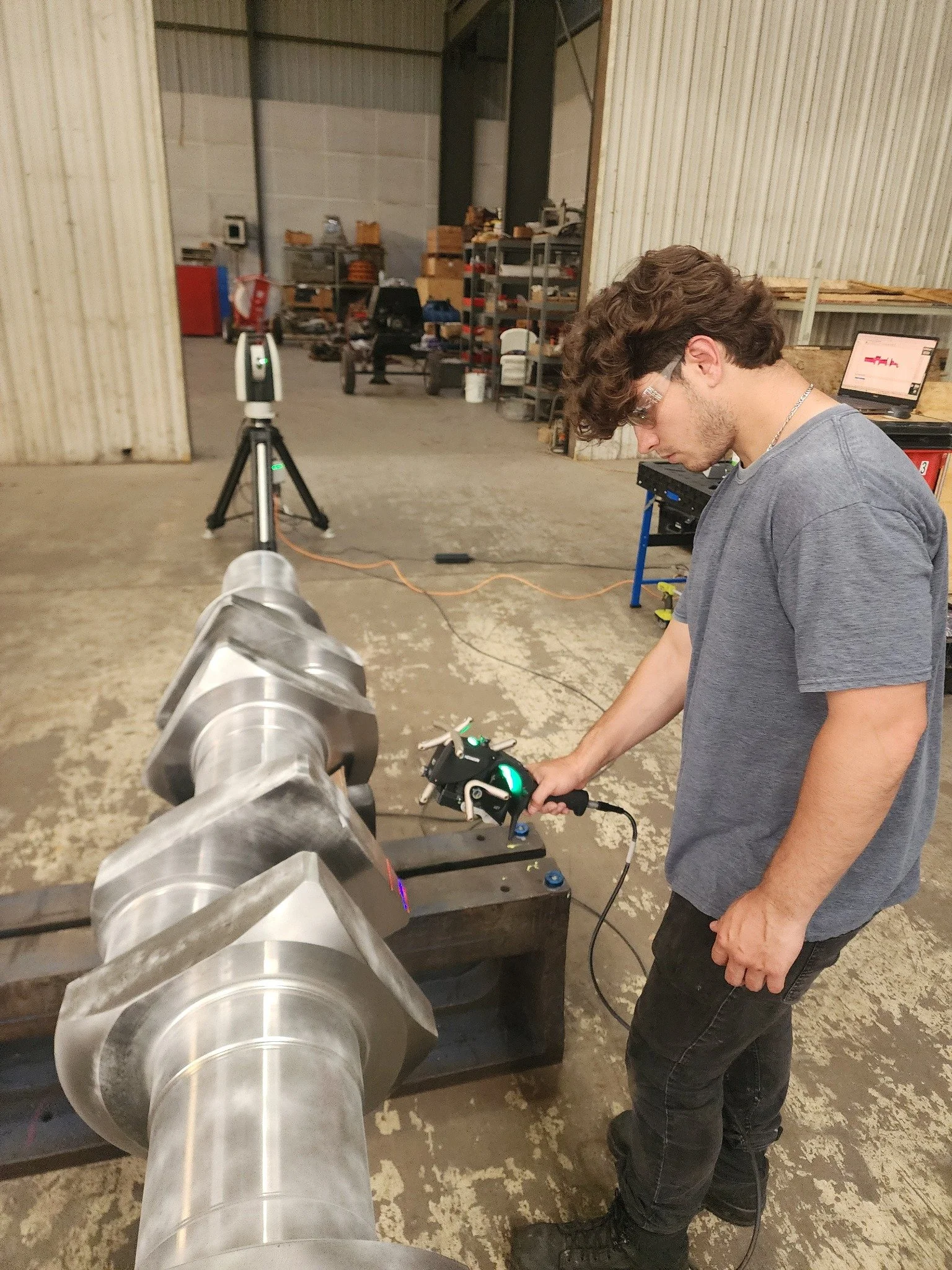 Technician scanning a crankshaft with a Leica AT960 and AS1 scanner