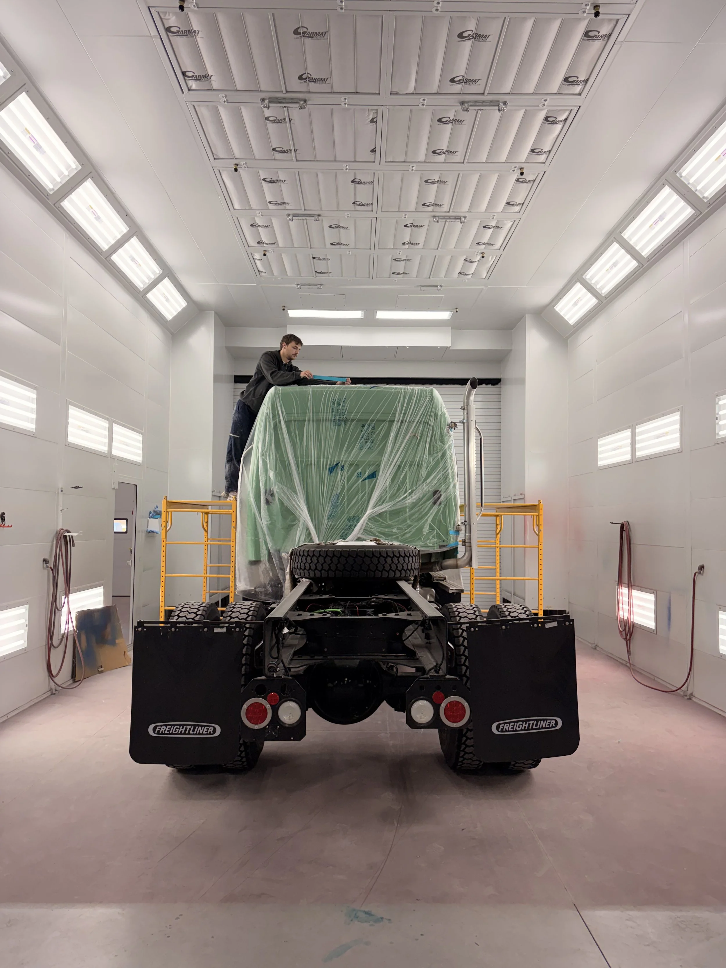 Technician inspecting vehicle damage during repair service at Optimus Group near Grand Rapids, MI.