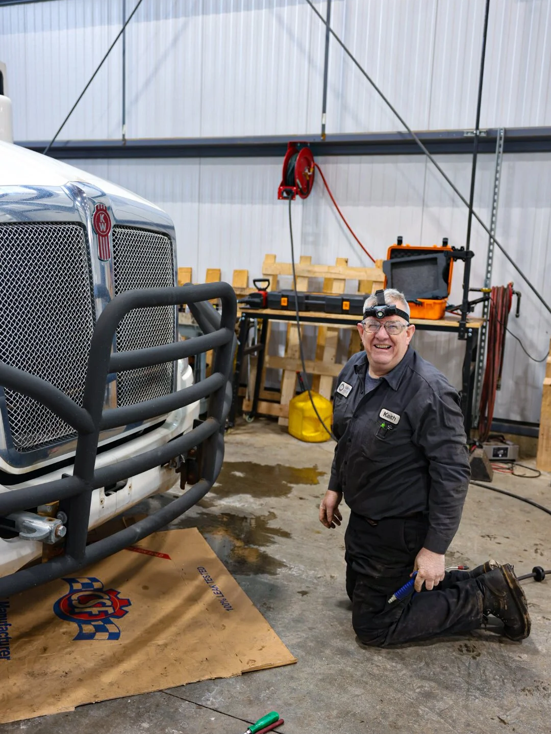 A mechanic at Optimus Fleet and Auto Repair working on a semi truck. Truck wash, trailer washout, diesel repair, propane autogas, fleet maintenance, Walker MI