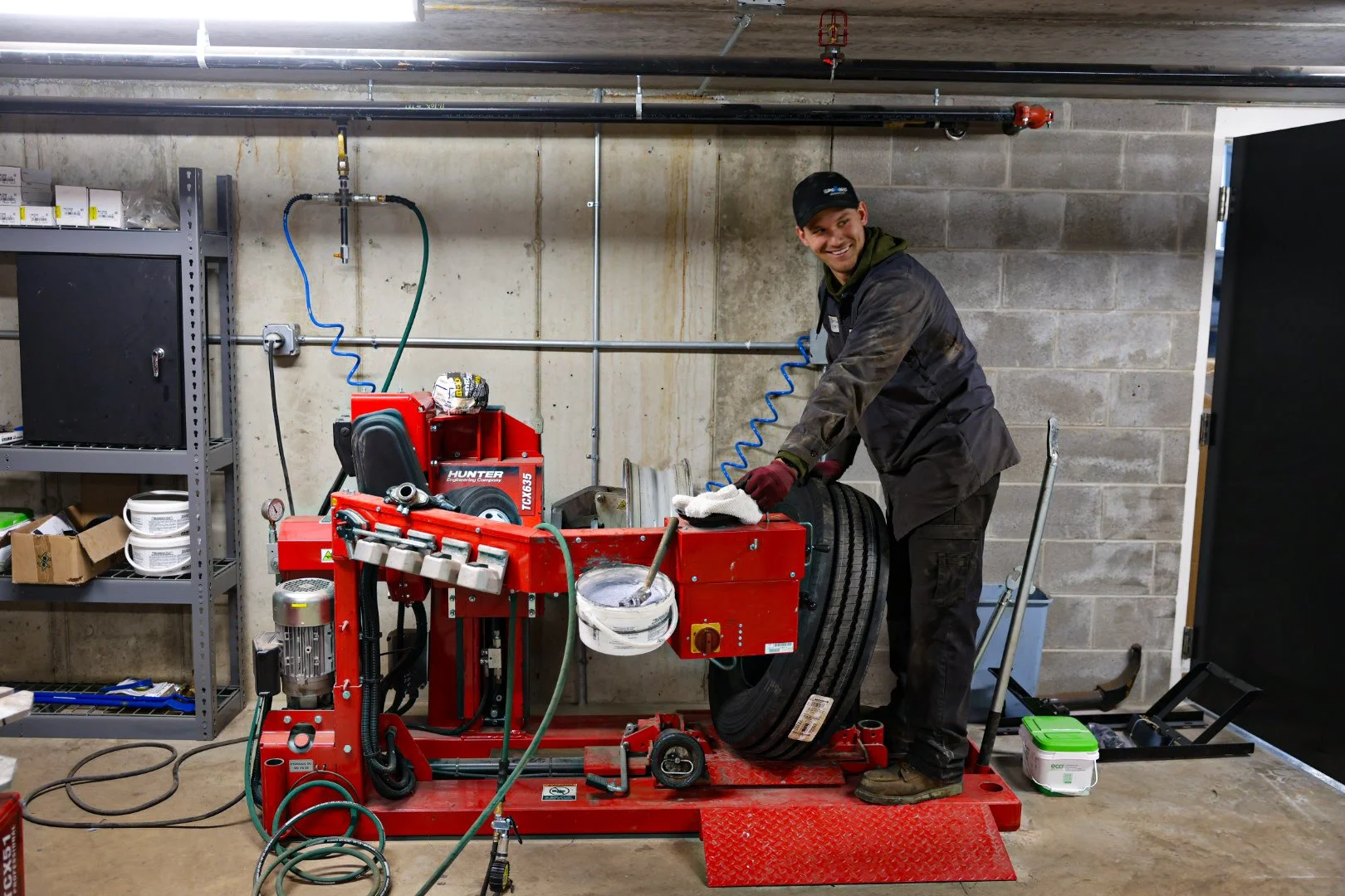 Technicians installing truck tire at Optimus Group fleet repair shop near Grand Rapids, MI.