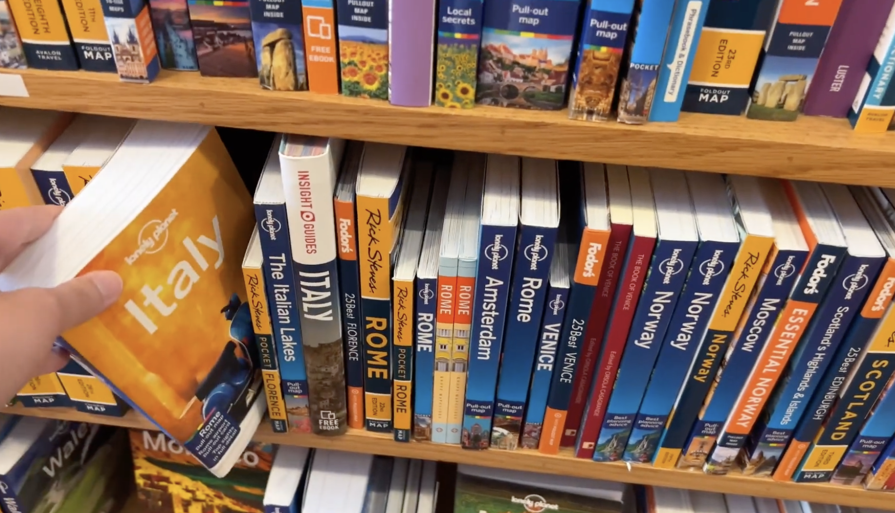 Bookshelf with Lonely Planet, Rick Steves, Fodor's, and other destination guide books