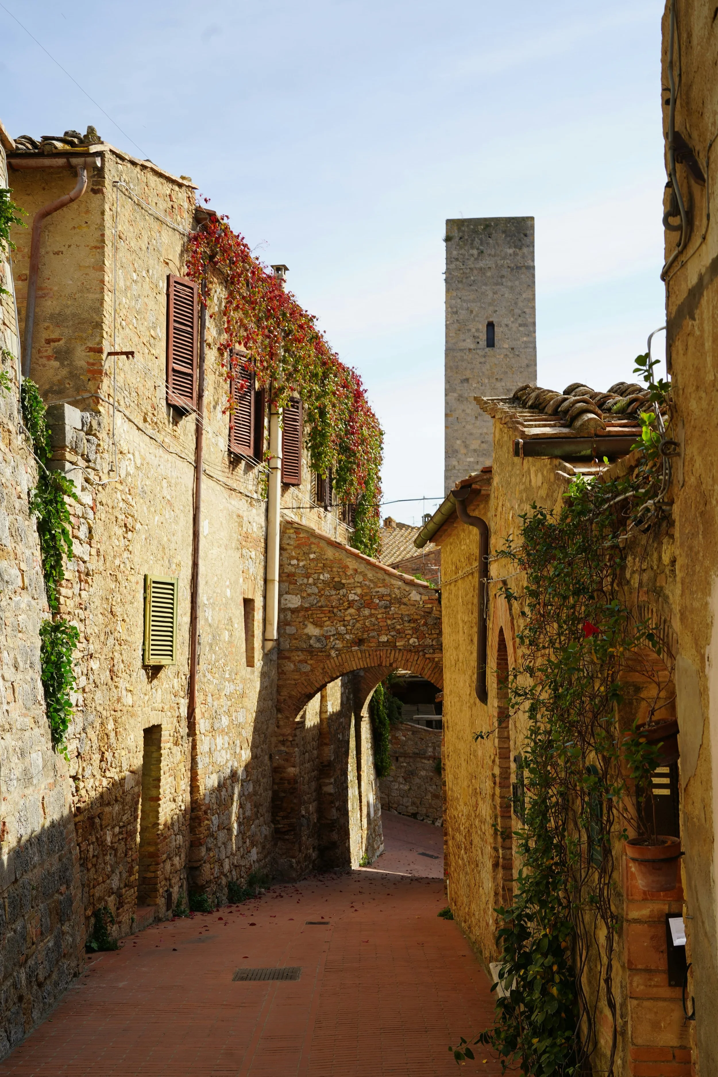 A scenic view of San Gimignano, a medieval hilltop town in Tuscany, Italy, known for its historic stone buildings and distinctive medieval towers rising above the rooftops.
