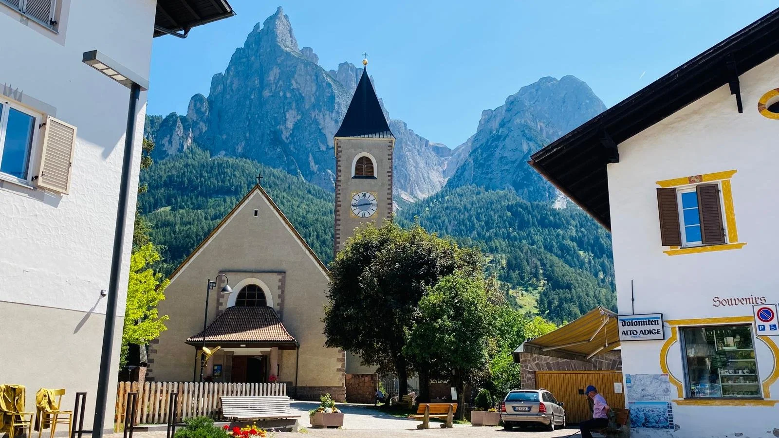 The Parish Church of the Holy Cross in Siusi allo Sciliar, South Tyrol, Italy, set beneath the dramatic peaks of the Sciliar massif in the Dolomites.
