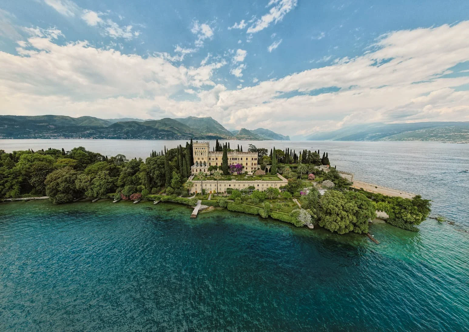 Isola del Garda, Lake Garda, Italy, featuring a Venetian Neo-Gothic palace surrounded by elegant terraced Italian gardens.