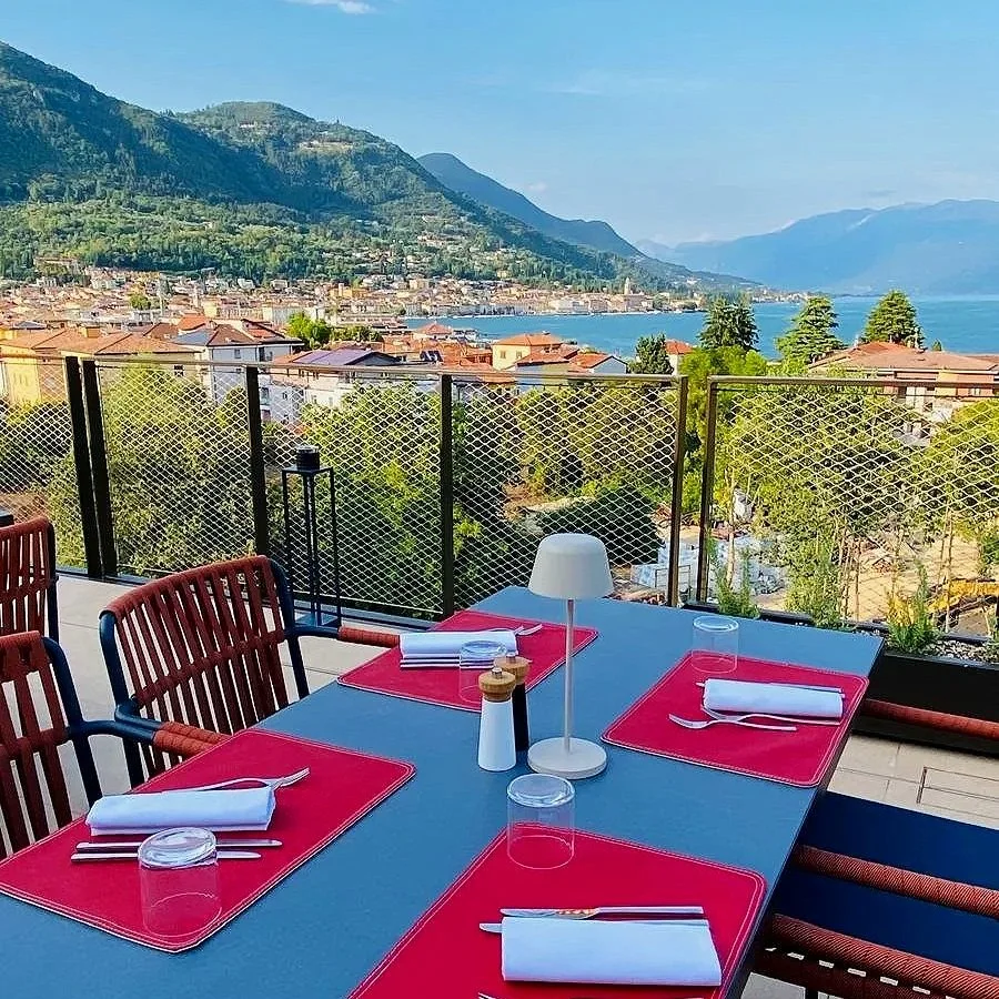 Falkensteiner Resort Lake Garda in Salò, Italy, featuring outdoor dining with panoramic views of the lake and surrounding mountains.