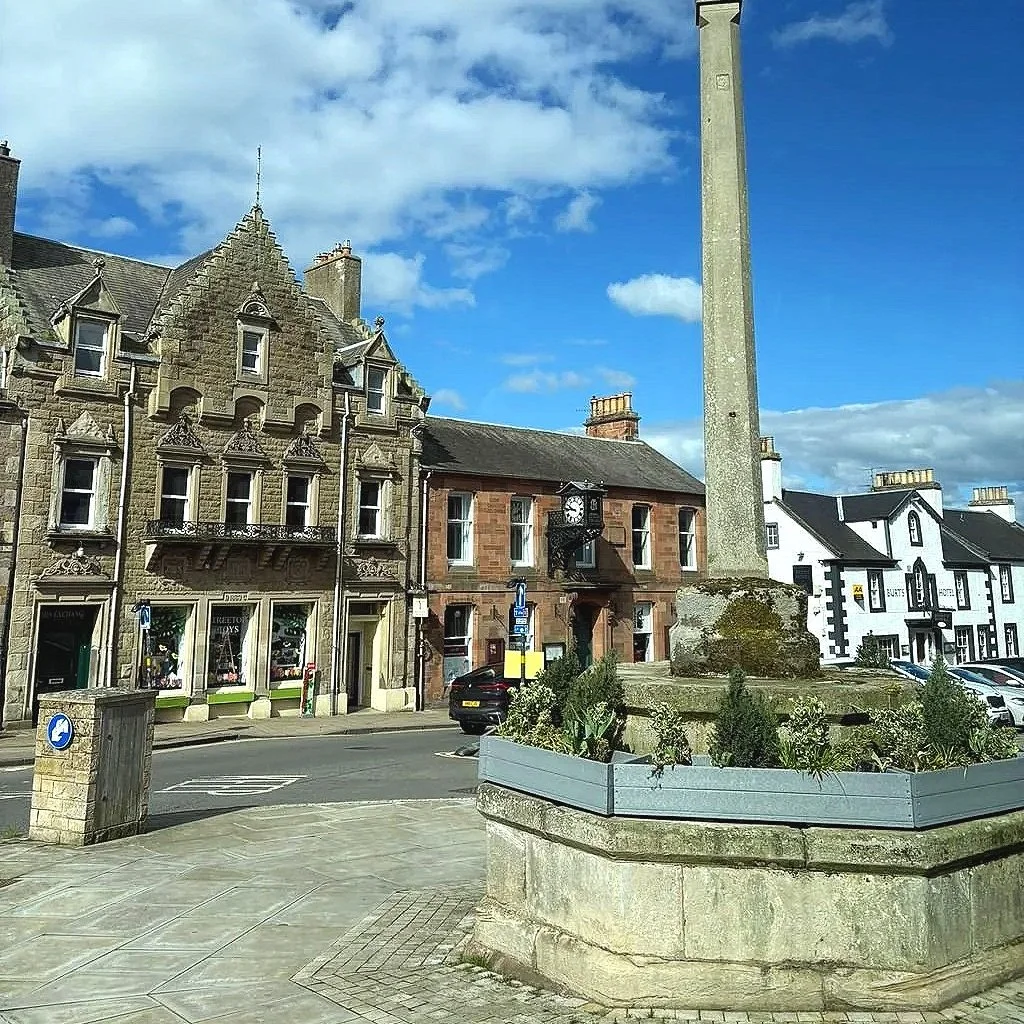 Mercat Cross, a historic stone cross with a unicorn finial in Market Square, Melrose, Scotland.