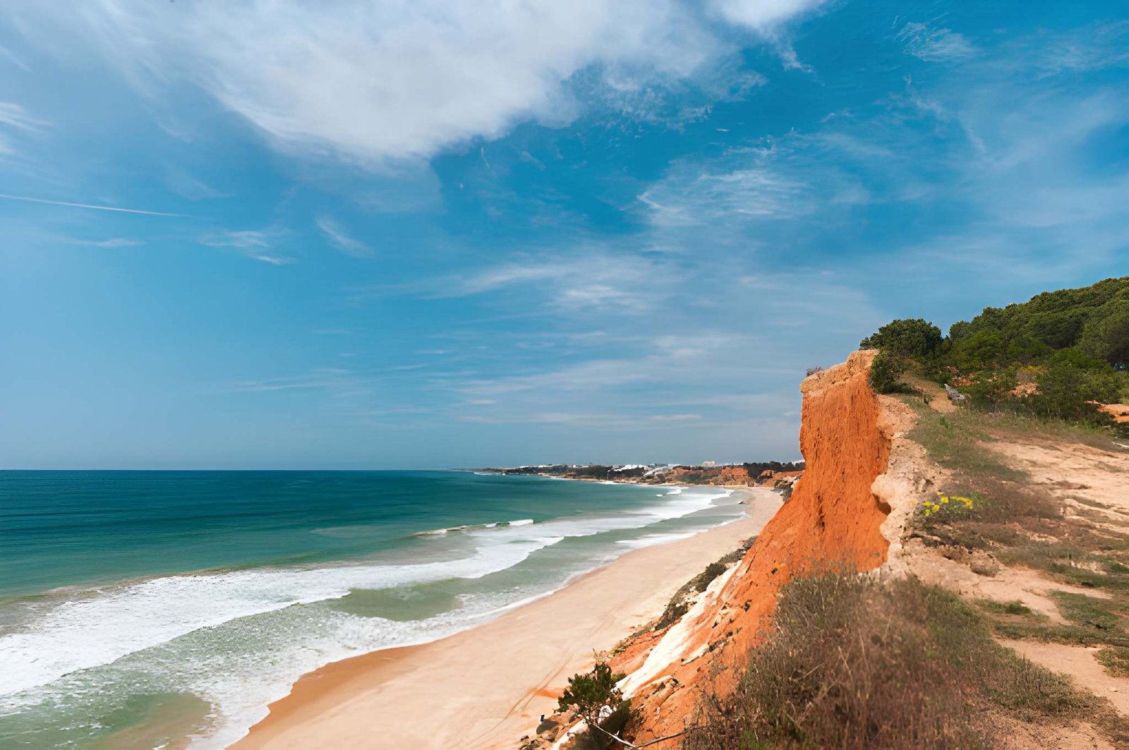Praia da Falésia, known for its sandy shoreline and dramatic red and golden cliffs in Portugal’s Algarve.