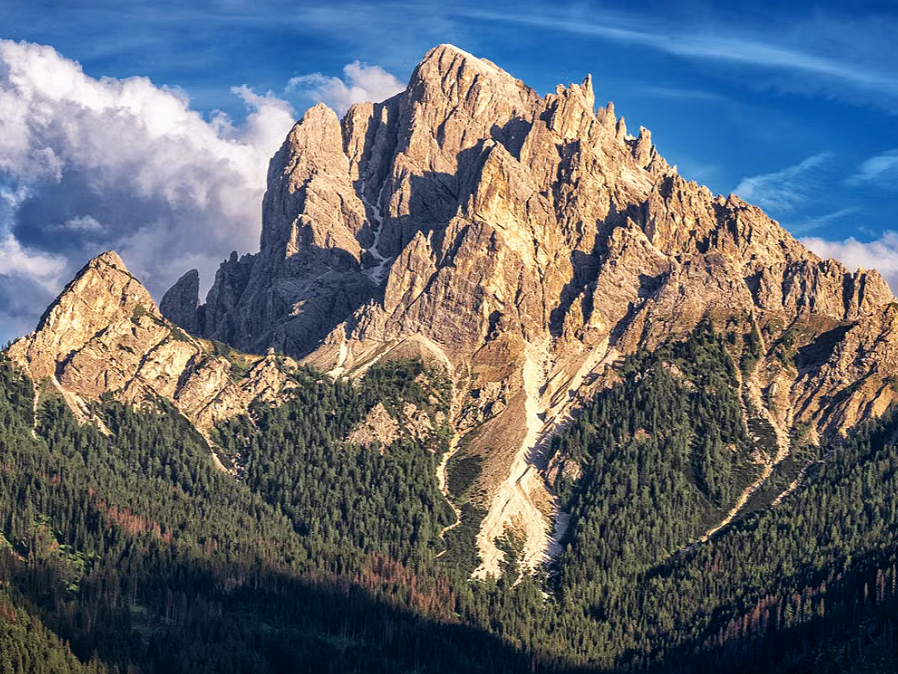 Trentino-South Tyrol, Italy, featuring rugged mountain peaks and lush alpine forests.