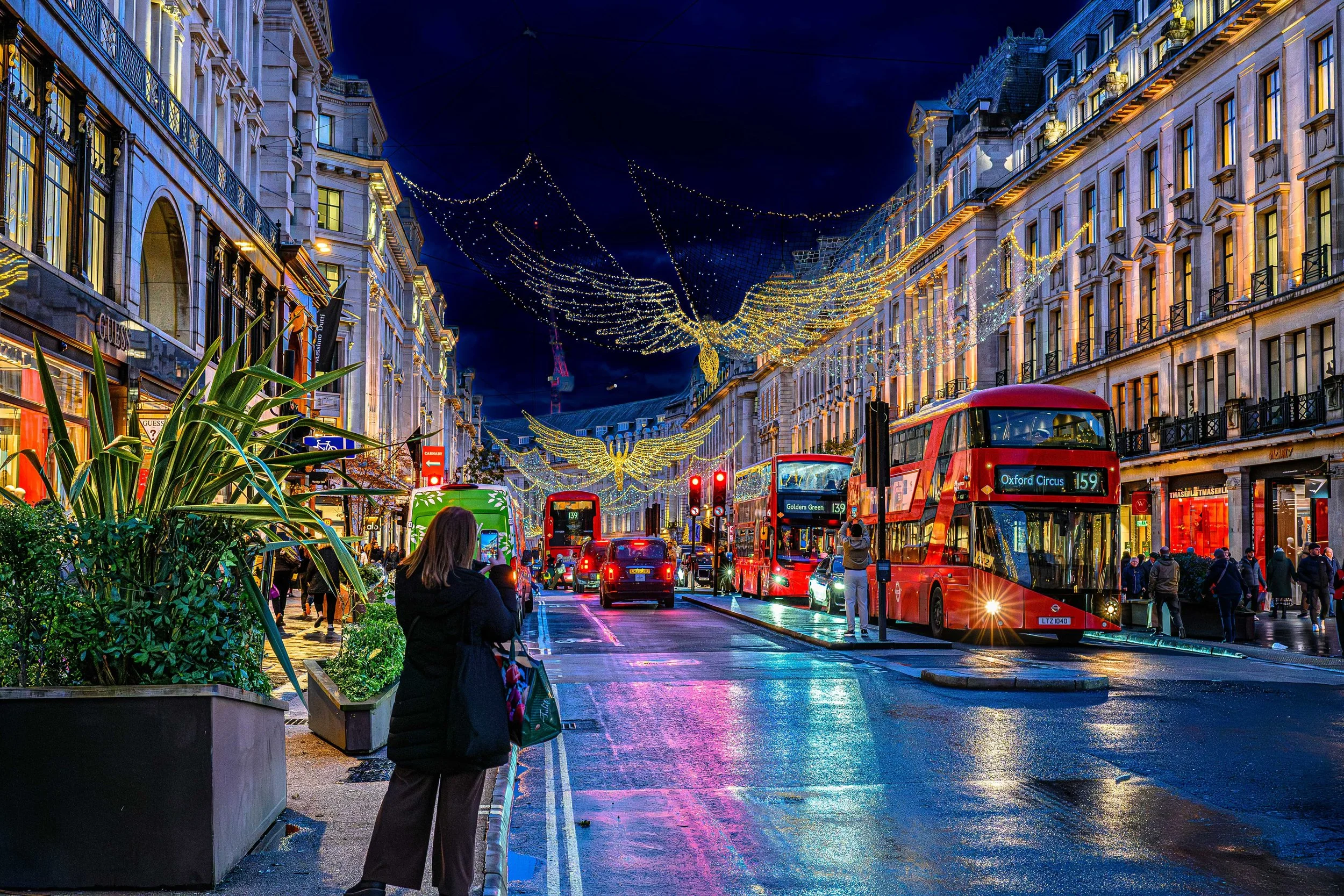 Regent Street in London, England, illuminated at night by its famous “Spirit of Christmas” angel lights.