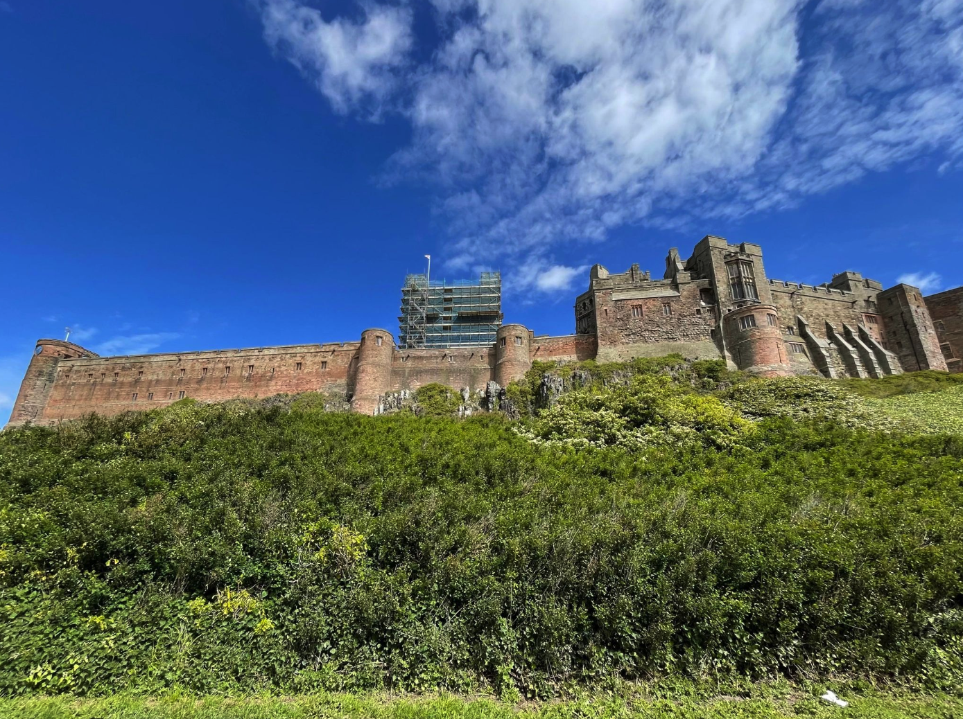 Bamburgh Castle, a historic coastal fortress perched on a rocky outcrop overlooking the North Sea in Northumberland, England.