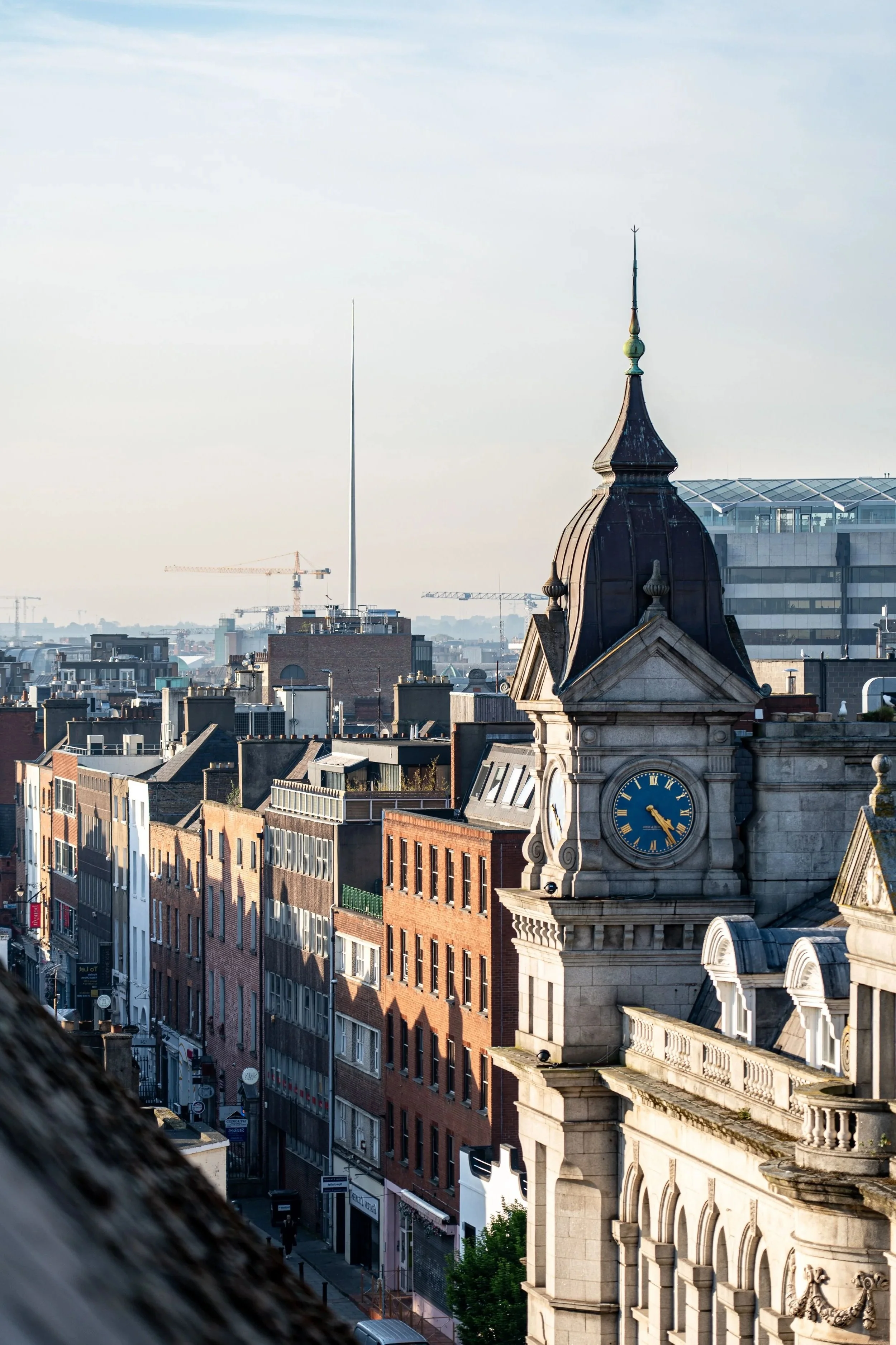 Dublin, Ireland, at sunrise, featuring the historic Custom House and The Spire rising above the city skyline.