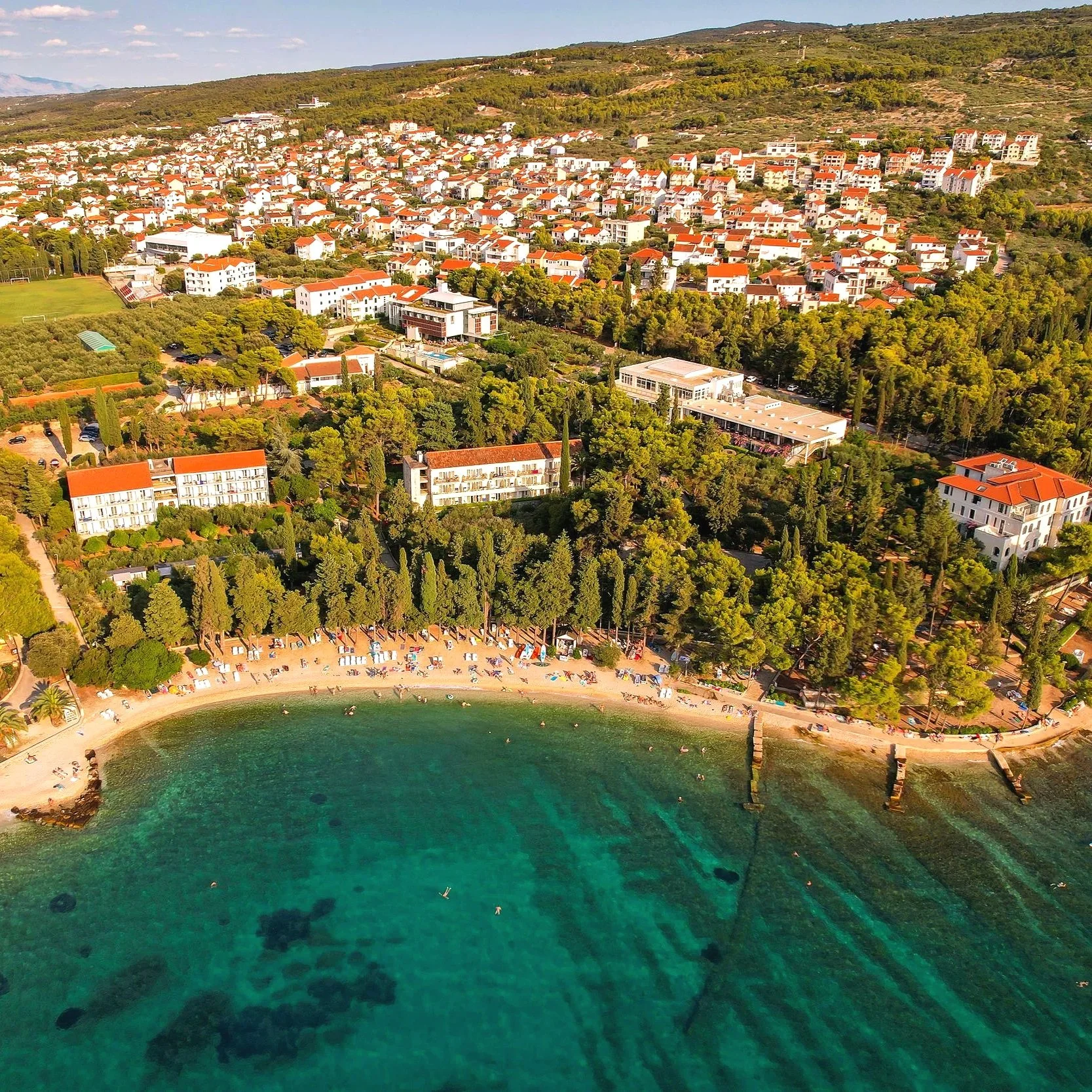 Brač Island, Croatia, featuring a scenic coastal town surrounded by a beautiful beach and lush Mediterranean greenery.