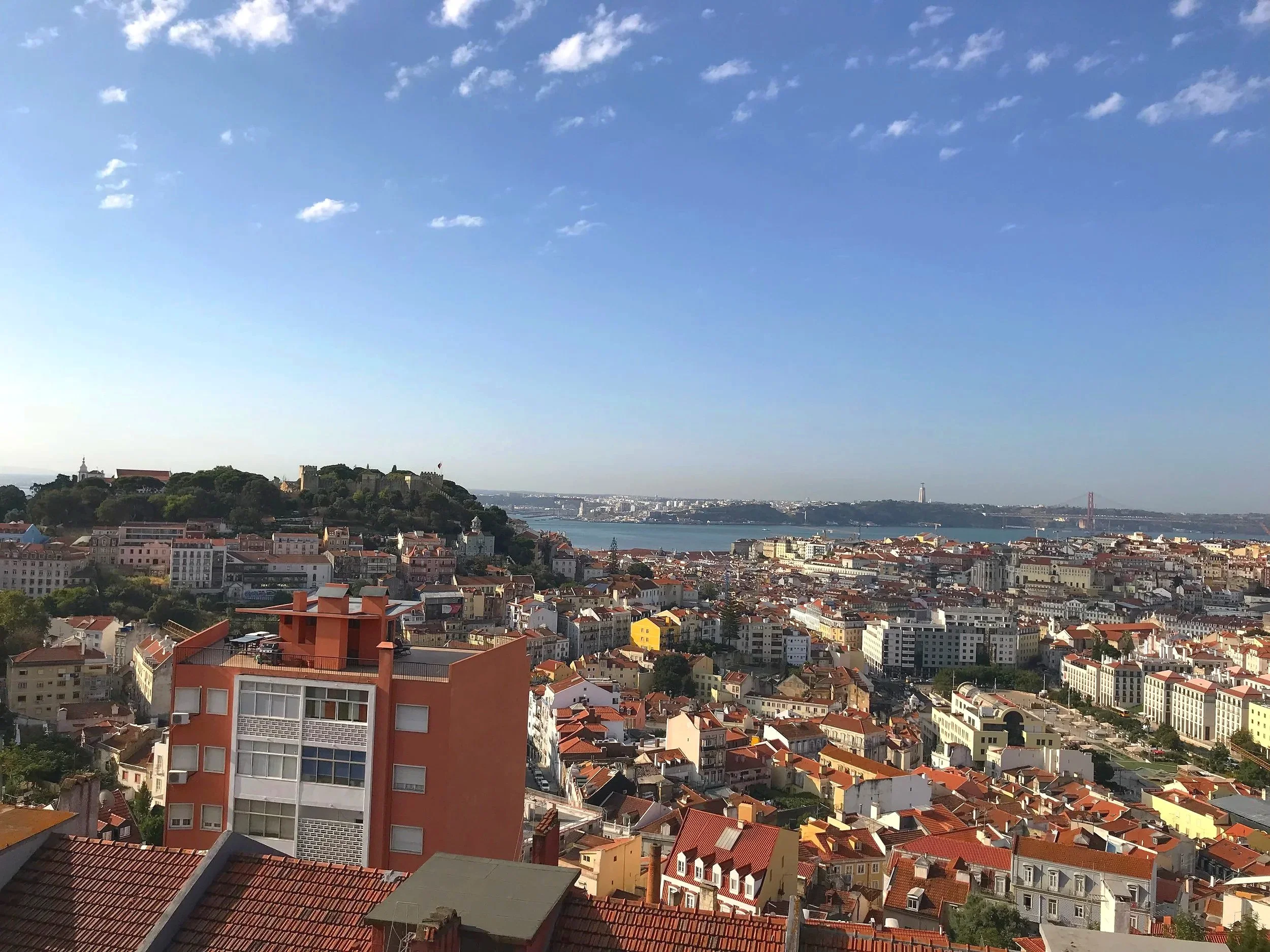 Panoramic view of Lisbon from Miradouro da Senhora do Monte, overlooking Alfama, Mouraria, and the Tagus River.