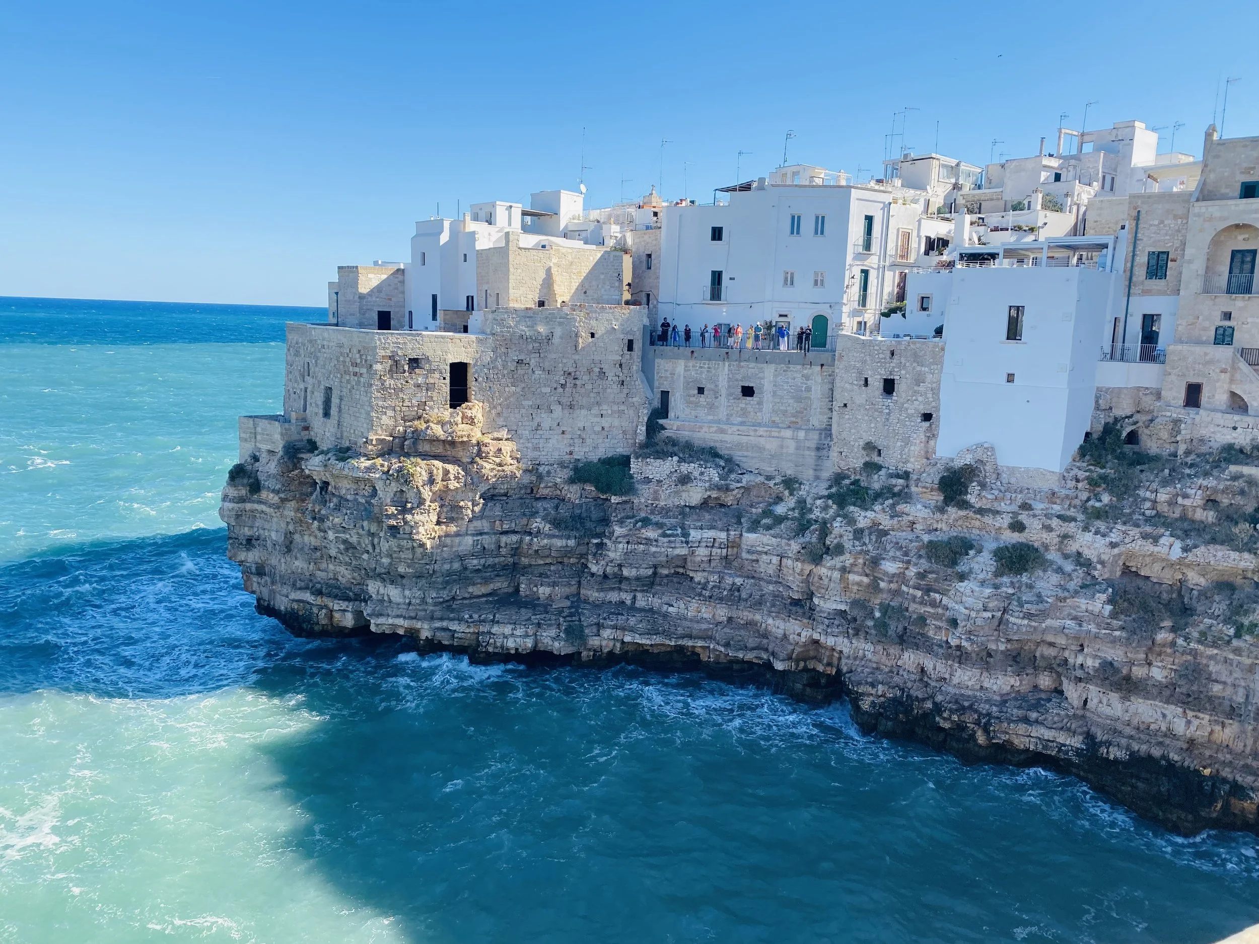 Polignano a Mare, a picturesque coastal town with dramatic limestone cliffs, whitewashed buildings, and Lama Monachile beach in Puglia, Italy.
