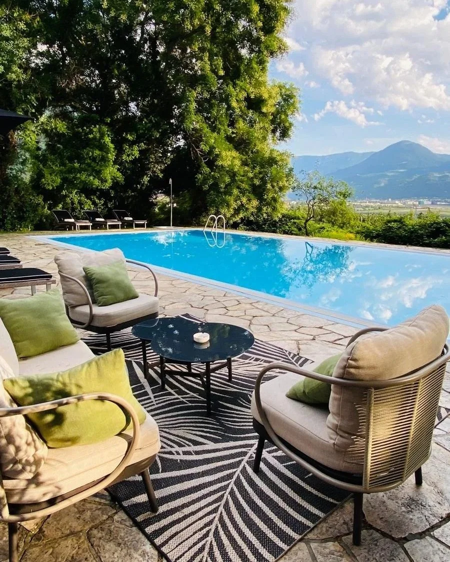 A Leading Park Retreat in Merano, South Tyrol, Italy, featuring an elegant outdoor pool surrounded by peaceful gardens and Alpine scenery.