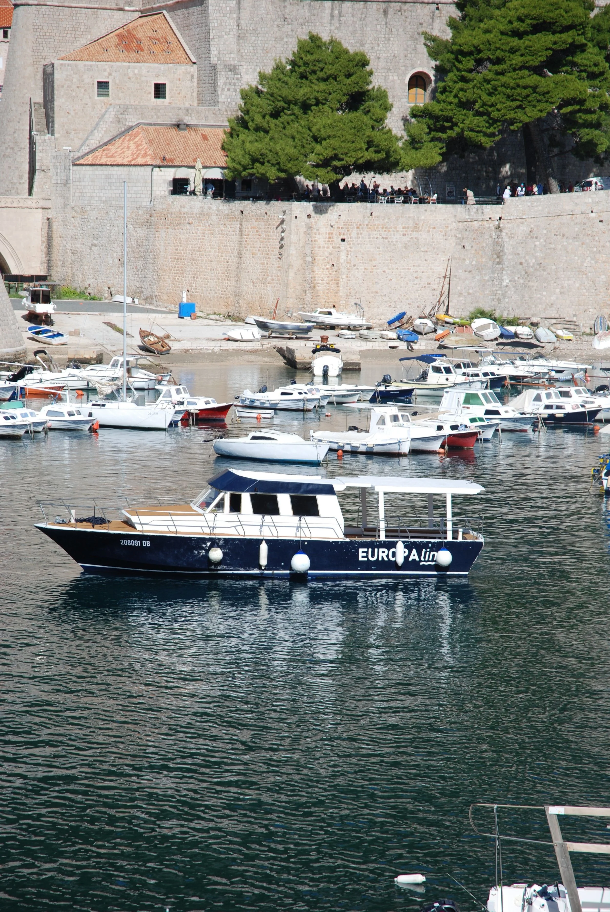 Dubrovnik’s Old Harbour, Croatia, featuring traditional boats along the Adriatic coast with the historic city walls rising in the background.